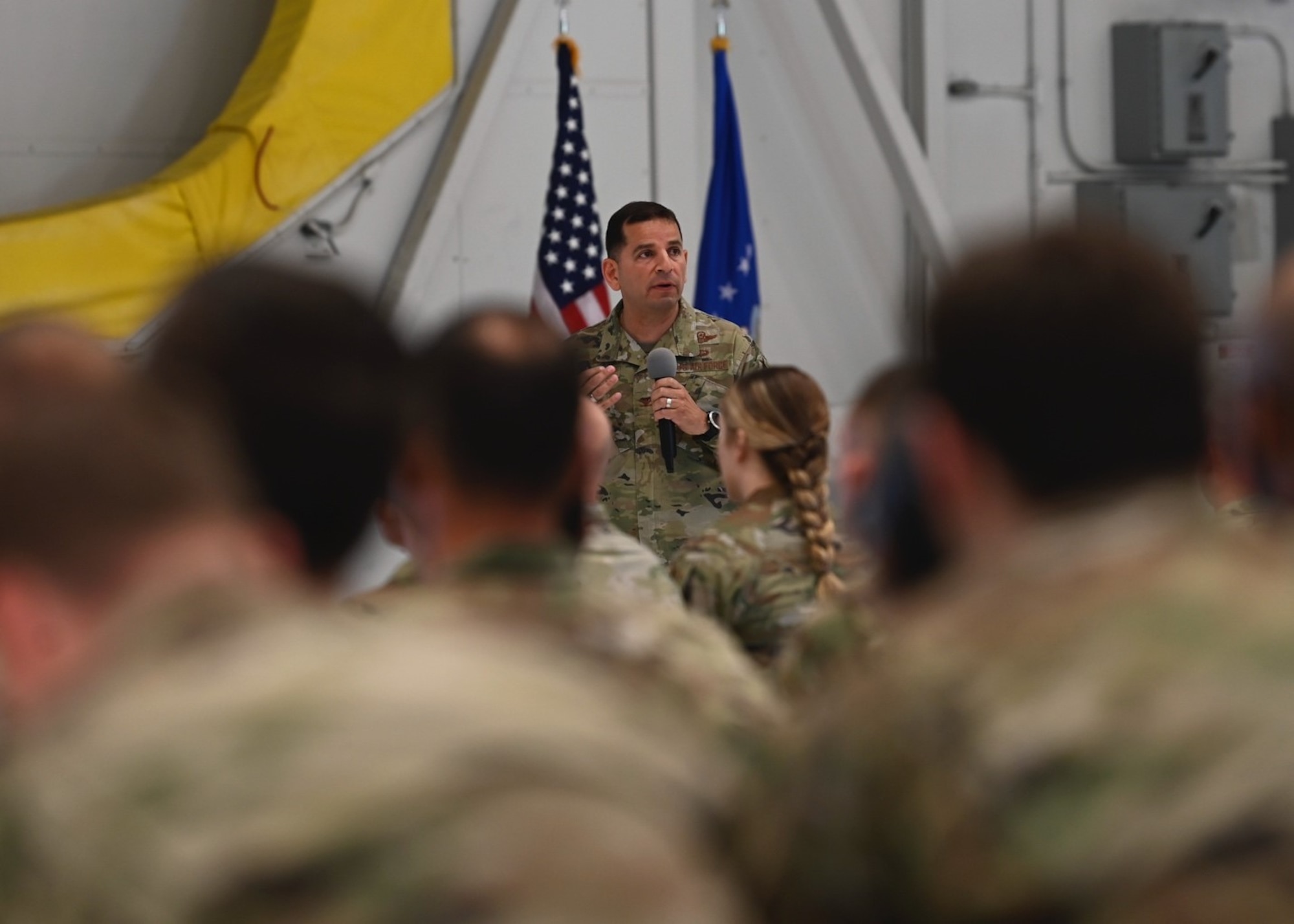 U.S. Air Force Col. Sergio Anaya, 62d Airlift Wing commander, addresses 62d AW Airmen during his first all-call as commander at Joint Base Lewis-McChord, Washington, July 31, 2023. The 62d AW has participated in a variety of exercises in the last two years that continue to pave the way for innovation and multi-domain capabilities from Team McChord Airmen, including Exercise Mobility Guardian, Operation Max Moose and Exercise Rainier War. Anaya referred to these exercises when he thanked Team McChord Airmen for their hard work and dedication to the mission. (U.S. Air Force photo by Senior Airman Callie Norton)