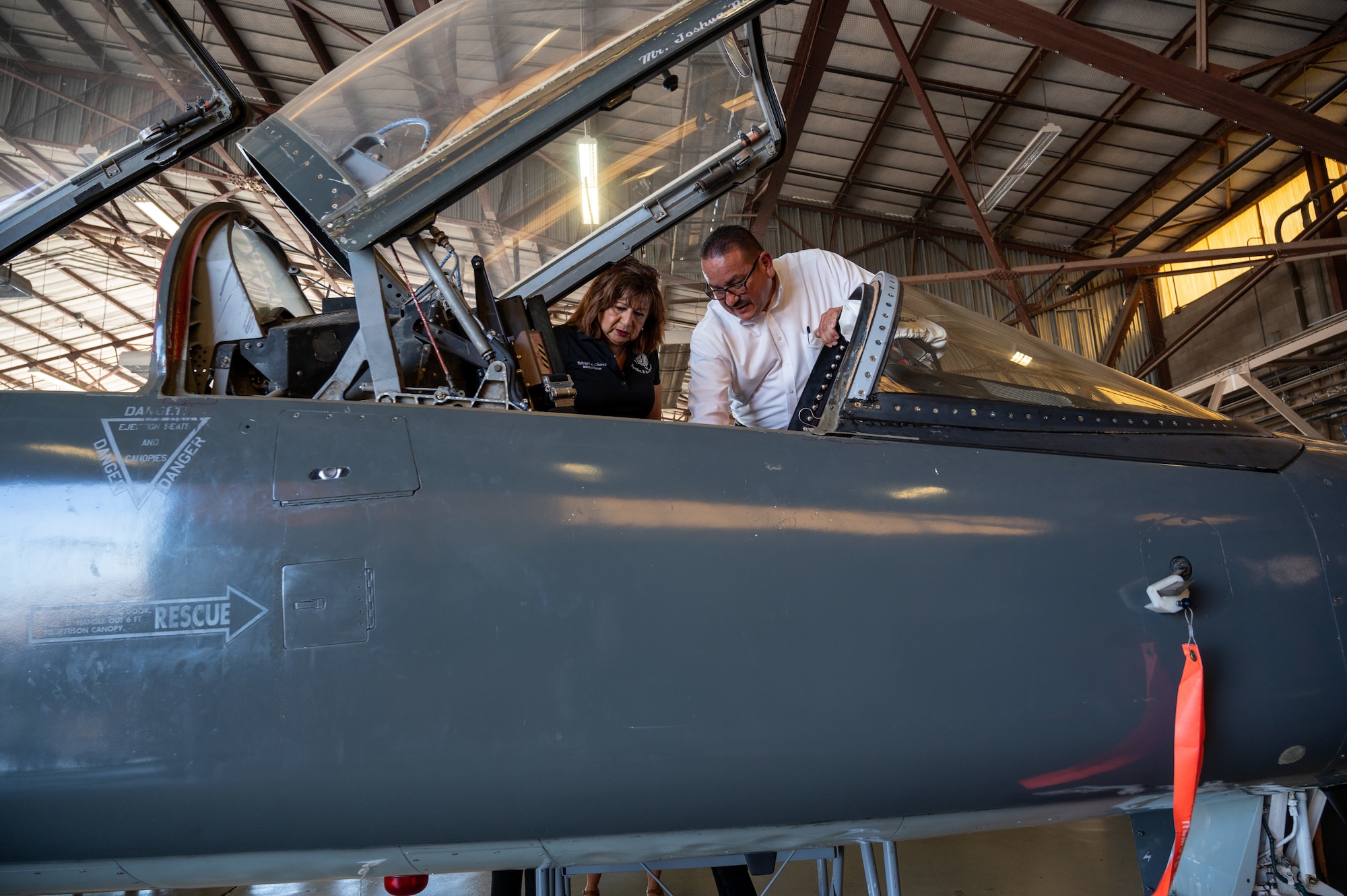 Rebekah Chavez (left), San Felipe Del Rio Consolidated Independent School District (SFDR-CISD) board of directors member, and Rene Martinez (right), 47th Maintenance Directorate supervisor, inspect the cockpit of a T-38C Talon undergoing maintenance at Laughlin Air Force Base, Texas, July 18, 2023. The Laughlin Educator Tour allowed SFDR-CISD leaders to see Laughlin's mission and discuss the future of the on-base education system. (U.S. Air Force photo by Senior Airman Nicholas Larsen)