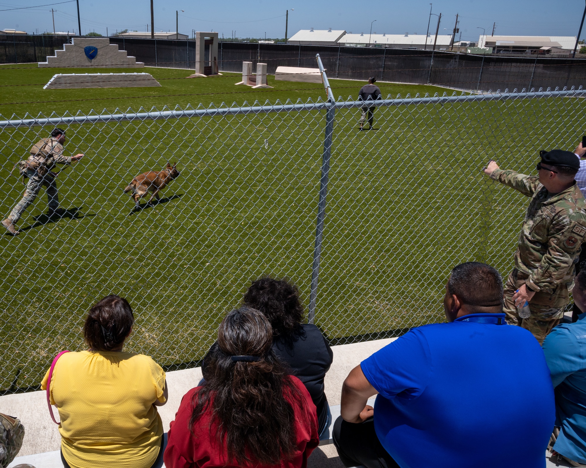 Education Leaders from the San Felipe Del Rio Consolidated Independent School District (SFDR-CISD) watch a Military Working Dog (MWD) demonstration at Laughlin Air Force Base, Texas, July 18, 2023. MWD's help provide essential security to  Laughlin AFB, helping ensure that those inside the base stay safe from a variety of threats, such as narcotics and explosives. (U.S. Air Force photo by Senior Airman Nicholas Larsen)