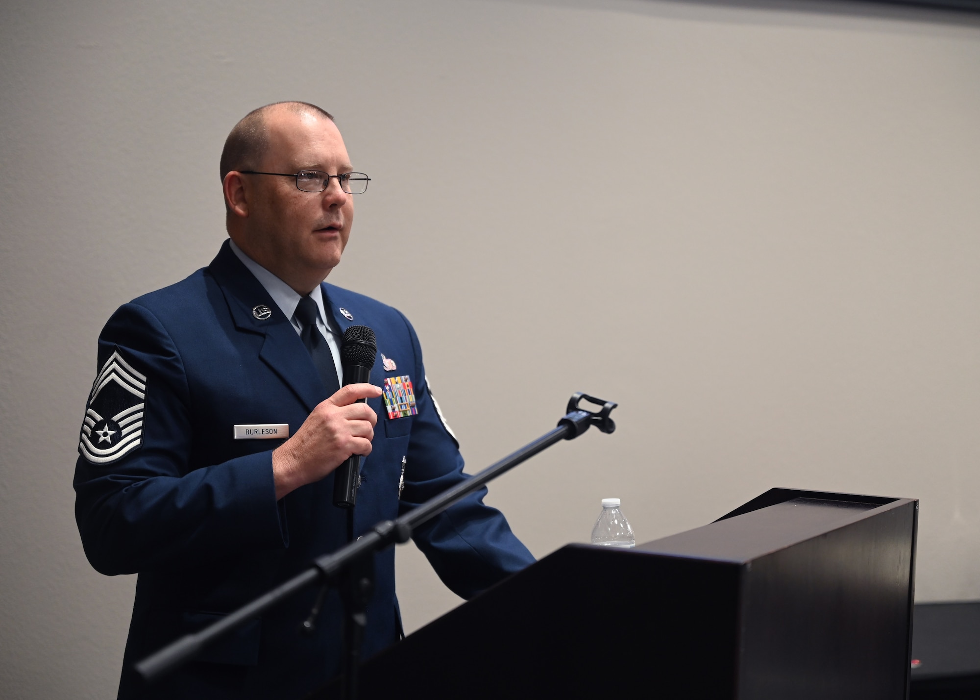 U.S. Air Force Chief Master Sgt. Anthony Burleson, 47th Mission Support Group superintendent, speaks at the Class 23-E Airman Leadership School graduation in the Powell Event Center, Goodfellow Air Force Base, Texas, July 20, 2023. Burleson encouraged the graduates to lean on each other and the noncommissioned officers around them. (U.S. Air Force photo by Senior Airman Ethan Sherwood.)