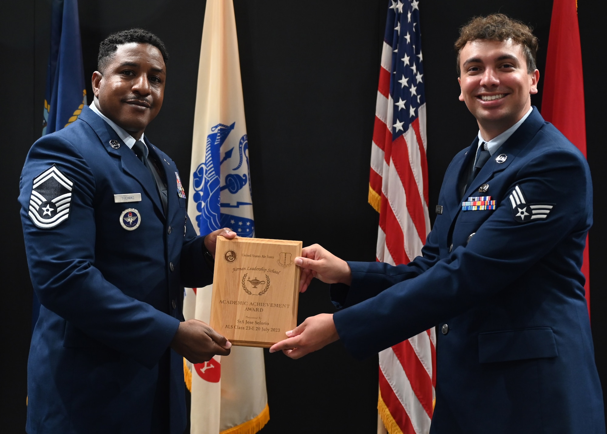U.S. Air Force Senior Master Sgt. Jarmaine Thomas, 17th Security Forces Squadron senior enlisted leader, presents the Academic Achievement Award to Senior Airman Jose Solorio, Class 23-E Airman Leadership School graduate, at the Class 23-E ALS graduation in the Powell Event Center, Goodfellow Air Force Base, Texas, July 20, 2023. This award is given to the student who demonstrated academic excellence in all performance tasks and the capstone exercise. (U.S. Air Force photo by Senior Airman Ethan Sherwood)