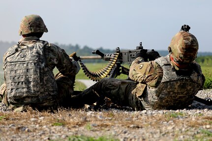 Spc. George Cooper, right, 91 Bravo, Wheeled Vehicle Mechanic, 3-411th Logistic Support Battalion, Camp Atterbury, Indiana fires 50-caliber machine gun rounds at a target during Operation Pershing Strike at Camp Atterbury, Indiana.