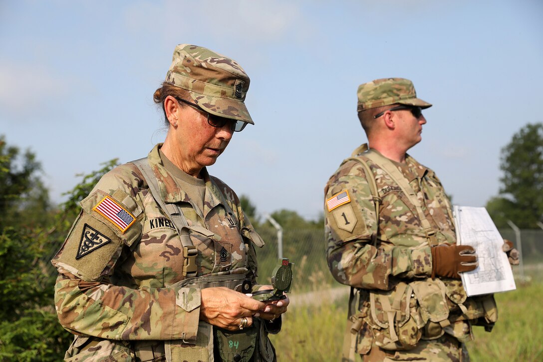 First Sgt. Michelle Kinell, left, 3-338th Transportation Support Battalion, Blacklick, Ohio, works with Capt. Robert Duncanson, S-3, 3-338th TSBN, to locate a point on a land navigation range during Pershing Strike at Camp Atterbury, Indiana.