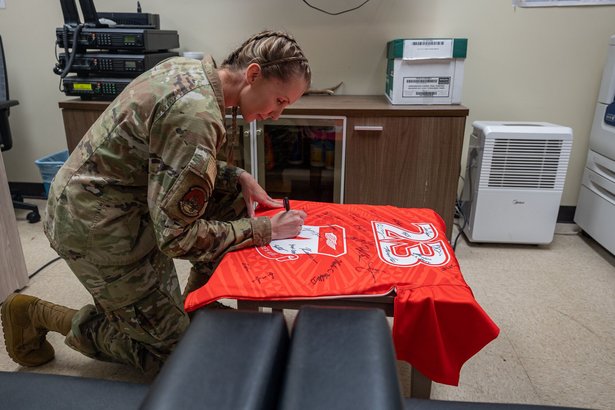 Photo of an Airman signing the official Linebacker of the Week jersey
