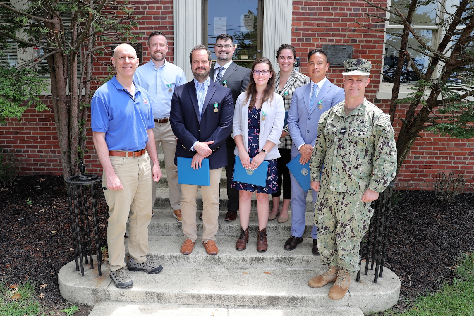 Naval Surface Warfare Center Indian Head Division (NSWC IHD) leadership honored eight personnel from the NSWC IHD Systems Engineering Department and Expeditionary Exploitation Unit One with Department of the Navy Civilian Service Commendation Medals at an awards presentation at the command, July 19. Pictured, left to right: NSWC IHD Technical Director Ashley Johnson, Ryan Hibbard, Adam Goldberg, Horacio Nochetto, Rachel Busby, Caroline Wiley, Rogelio (Roger) Ilamni and NSWC IHD Commanding Officer Capt. Eric Correll. Not pictured are award recipients Ryan Kerth and Otto Quinones-Melendez.