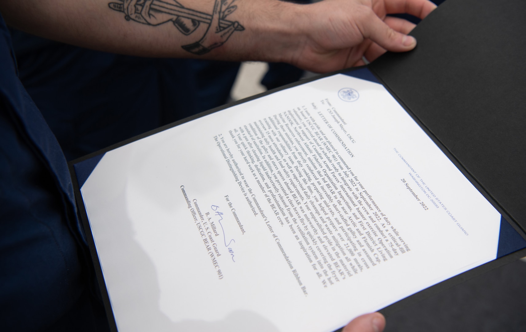 U.S. Coast Guard Petty Officer 3rd Class Joseph Mayer, a culinary specialist temporarily assigned to USCGC Bear (WMEC 901), reads his citation after being awarded a letter of commendation ribbon at quarters, Atlantic Ocean, Sep. 13, 2022. Mayer was being rewarded for his continued hard work demonstrated over the course of his time aboard the Bear. (U.S. Coast Guard photo by Petty Officer 3rd Class Matthew Abban)