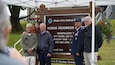 Maj. Gen. Torrence Saxe, adjutant general of 
the Alaska National Guard and commissioner 
of the Department of Military and Veterans 
Affairs, stands with friends and brothers in 
arms of Specialist Four Harmon in front of the 
new Kodiak Reediness Center sign July 27, 
2023, in Kodiak, Alaska.