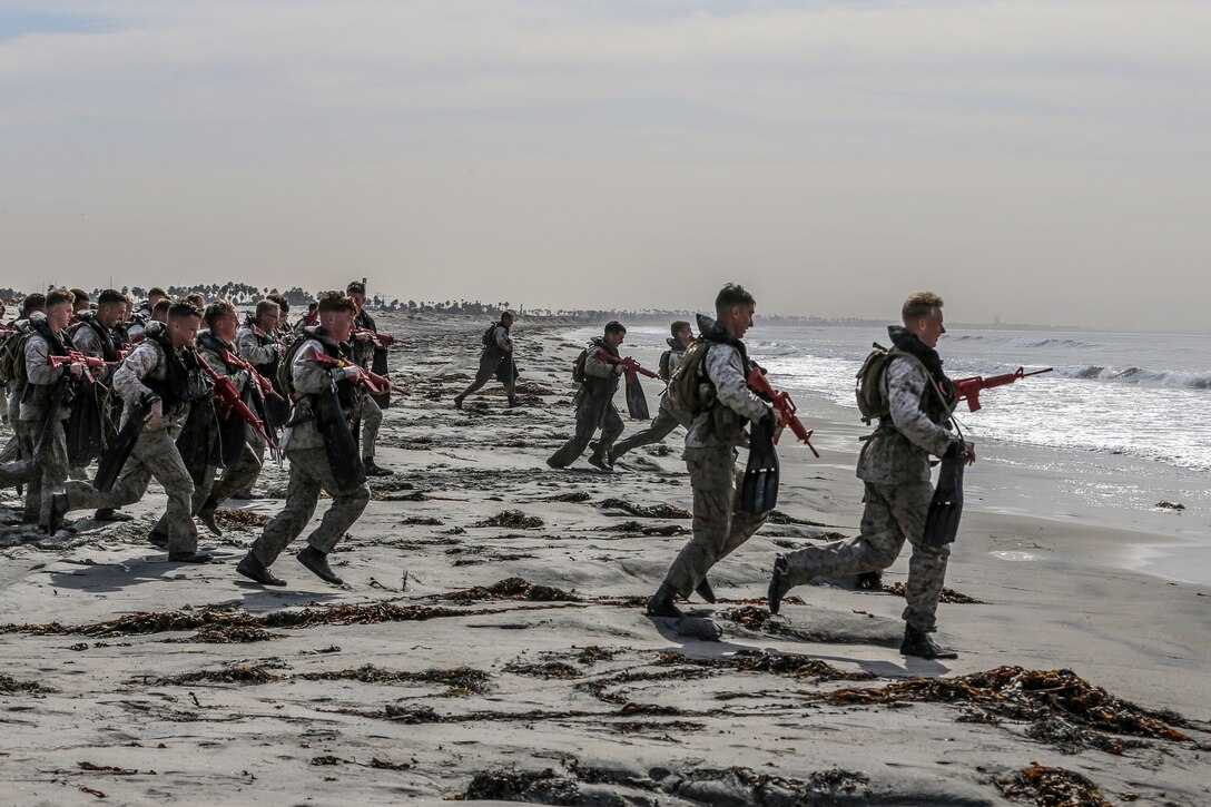U.S. Marines with Basic Reconnaissance Course run into the ocean during clandestine landing and withdraw training at Naval Amphibious Base Coronado, California, Oct. 30, 2019. BRC is one of the many courses taught by the staff at Reconnaissance Training Company, Advanced Infantry Training Battalion, School of Infantry - West.  The course  provides students with the basic knowledge of reconnaissance doctrine, concepts, and techniques with emphasis on amphibious entry and extraction, beach reconnaissance and reconnaissance patrolling skills. (Marine Corps photo by Lance Cpl. Andrew Cortez)