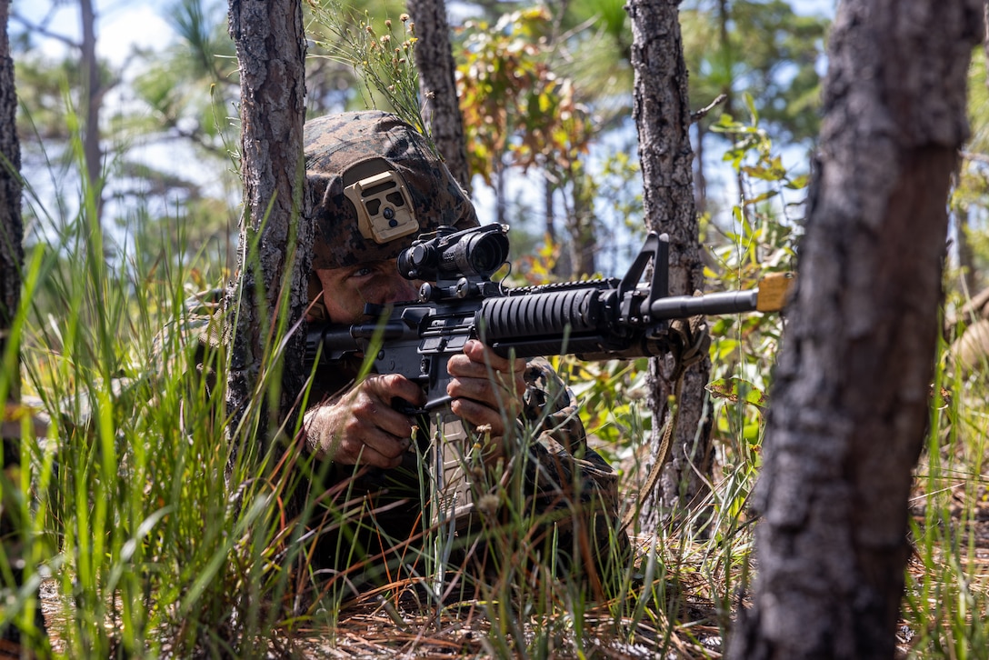 Naval Reserve Officers Training Corps (NROTC) Midshipman Sam Nutting sights in during a fire and maneuver exercise as part of Career Orientation Training for Midshipmen (CORTRAMID) on Camp Lejeune, North Carolina, July 27, 2023. The CORTRAMID is a basic introduction and training event to familiarize NROTC Midshipmen with the primary warfare designators  that they will serve in, along with providing them with exposure to what is often their first Marine Corps fleet experience. (U.S. Marine Corps photo by Lance Cpl. Osmar Gutierrez)