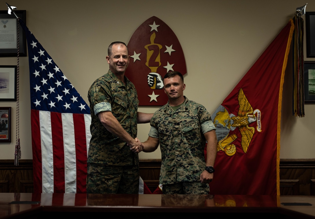 U.S. Marine Corps Col. Robert Hallett, the 2d Marine Division assistant division commander, presents Sgt. Peyton Nott, a motor transportation chief with 1st Battalion, 10th Marine Regiment, with a challenge coin for his recent meritorious promotion to sergeant by the 36th Assistant Commandant of the Marine Corps, Gen. Eric M. Smith, on Camp Lejeune, North Carolina, July 31, 2023. Nott was promoted as a result of his exceptional performance and leadership while holding a billet reserved for a gunnery sergeant. (U.S. Marine Corps photo by Cpl. Ethan Robert Jones)