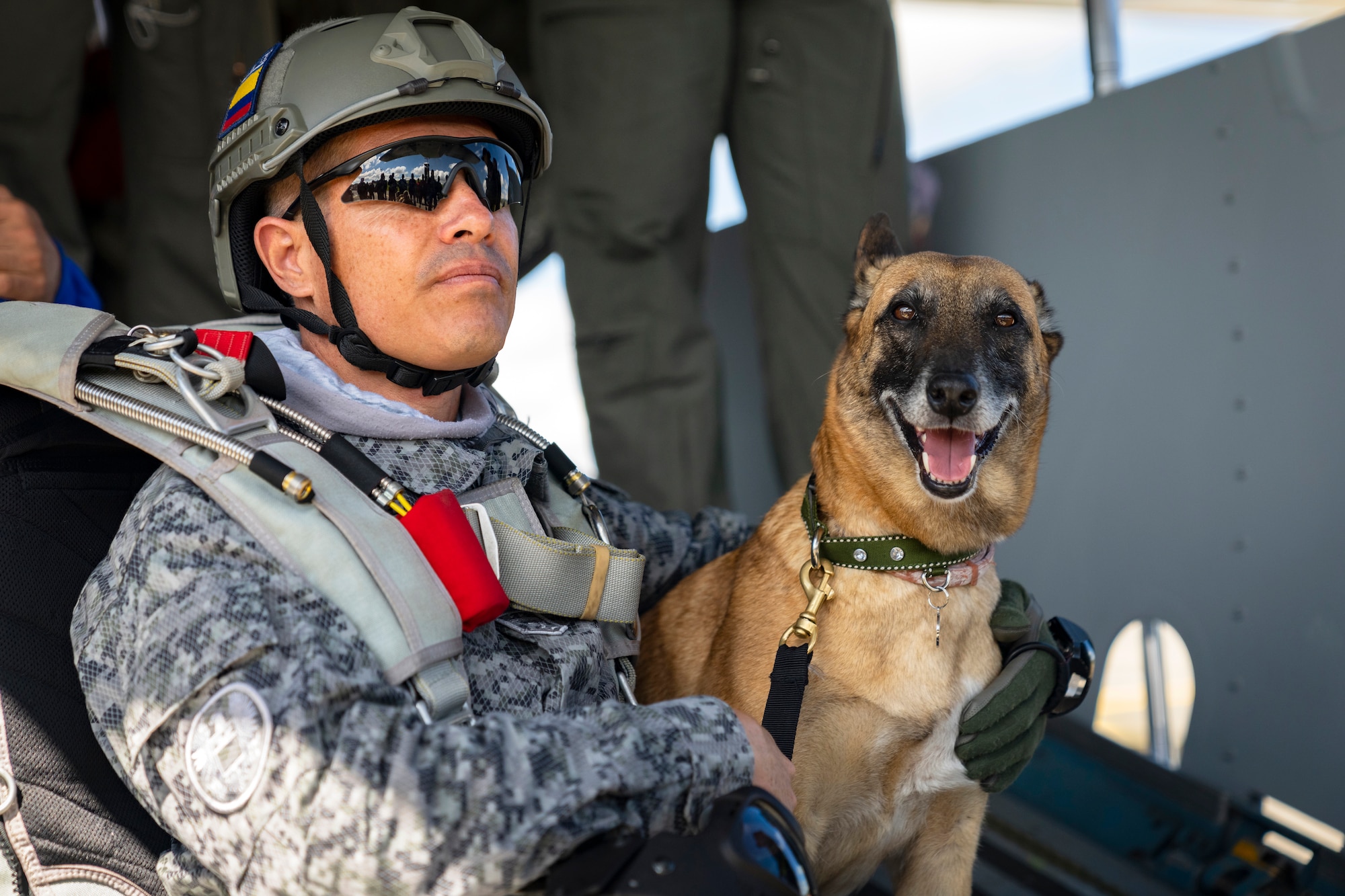 A Colombian Air Force pararescue specialist and K-9, with Águila De Gules parachuting team, listen to a pre-jump brief during F-AIR Colombia International Aeronautics and Space Fair at Combat Air Command No. 5, in Rionegro, Colombia, July 15, 2023. Activities like F-AIR help to strengthen international partnerships, enhancing interoperability and improving the collective readiness with partner nations to conduct a range of potential future operations. U.S. Air Force photo by Tech. Sgt. Rachel Maxwell
