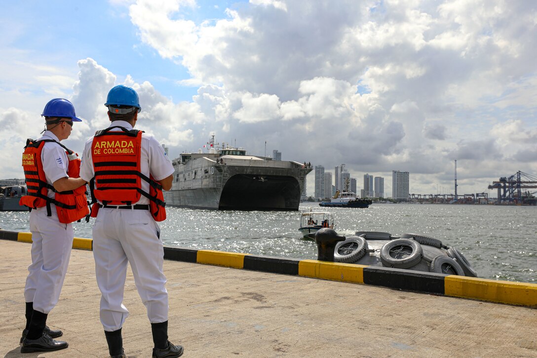 Colombian Navy Sailors observe as the expeditionary fast transport USNS Burlington (T-EFP 10) arrives at Colombian Base Naval Logistica ARC "Bolivar", Colombia in preparation for UNITAS LXIV, July 2, 2023. Burlington is one of 26 vessels slated to participate in UNITAS LXIV, the world’s longest running maritime exercise, July 11-21. Colombia is hosting UNITAS LXIV this year with nearly 7,000 people from 20 nations