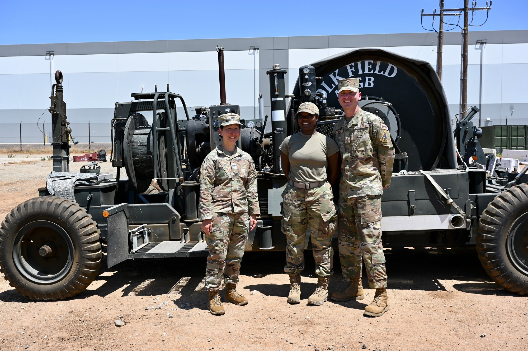 Col. Mia Walsh and SBD 3 First Sergeant, Master Sgt. Caldwell pose with Staff Sgt. Moore in front of the Mobile Aircraft Arresting System.