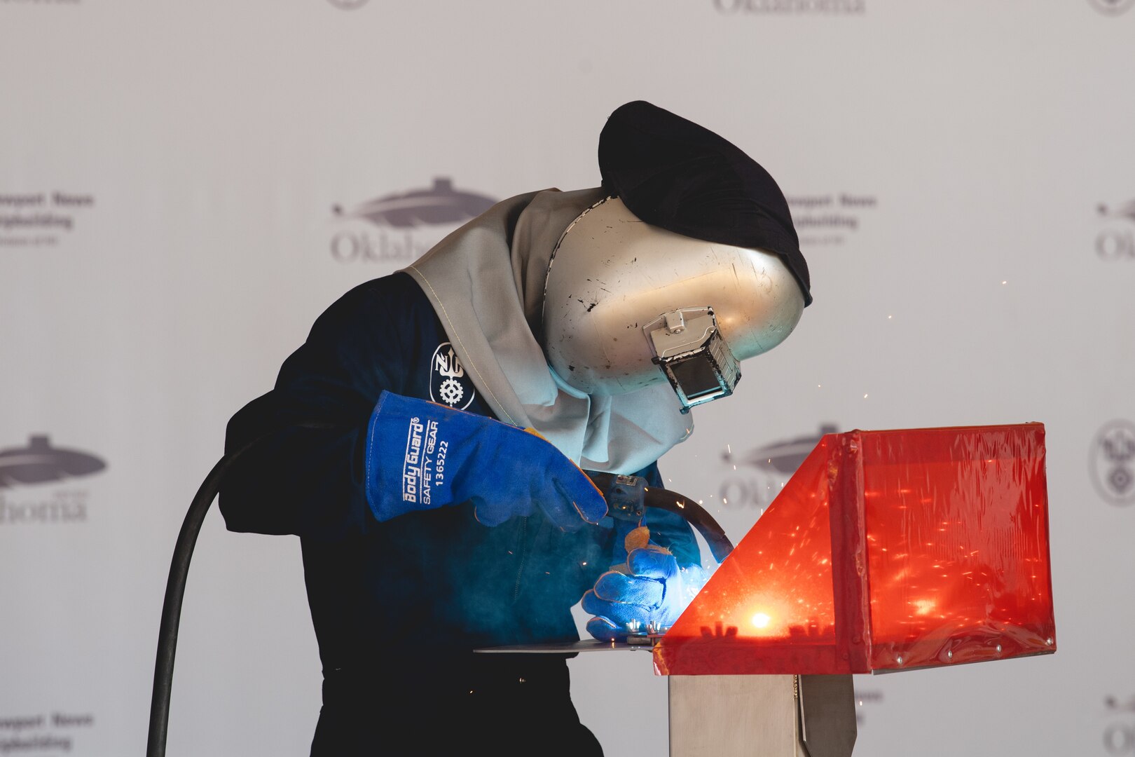 Welder Alex VanCampen welds the initials of ship’s sponsor Mary “Molly” Slavonic onto a metal plate during the keel authentication ceremony for Virginia-class attack submarine Oklahoma (SSN 802) on Wednesday, August 2, 2023 at HII’s Newport News Shipbuilding division. The metal plate will remain affixed to the submarine throughout its life (Photo by Lexi Whitehead/HII).