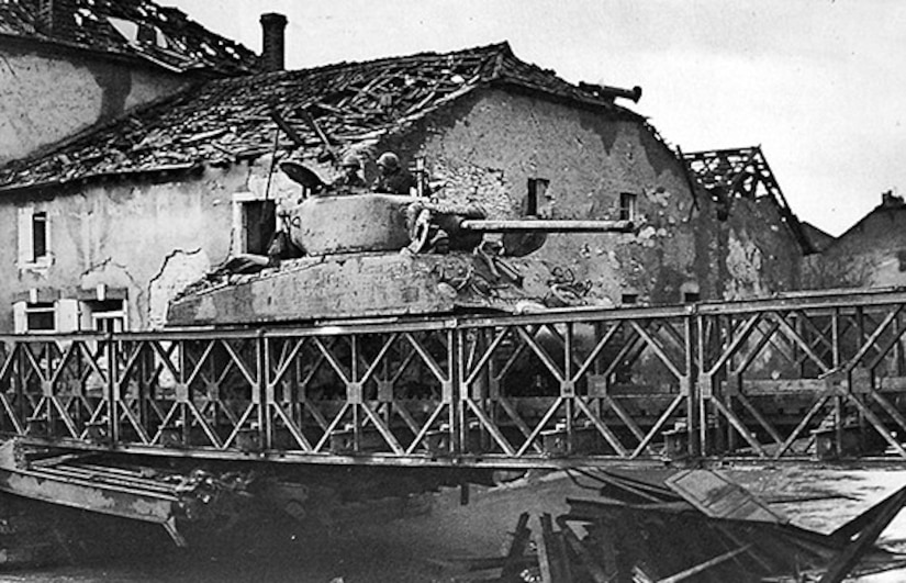 A tank rolls across a bridge.