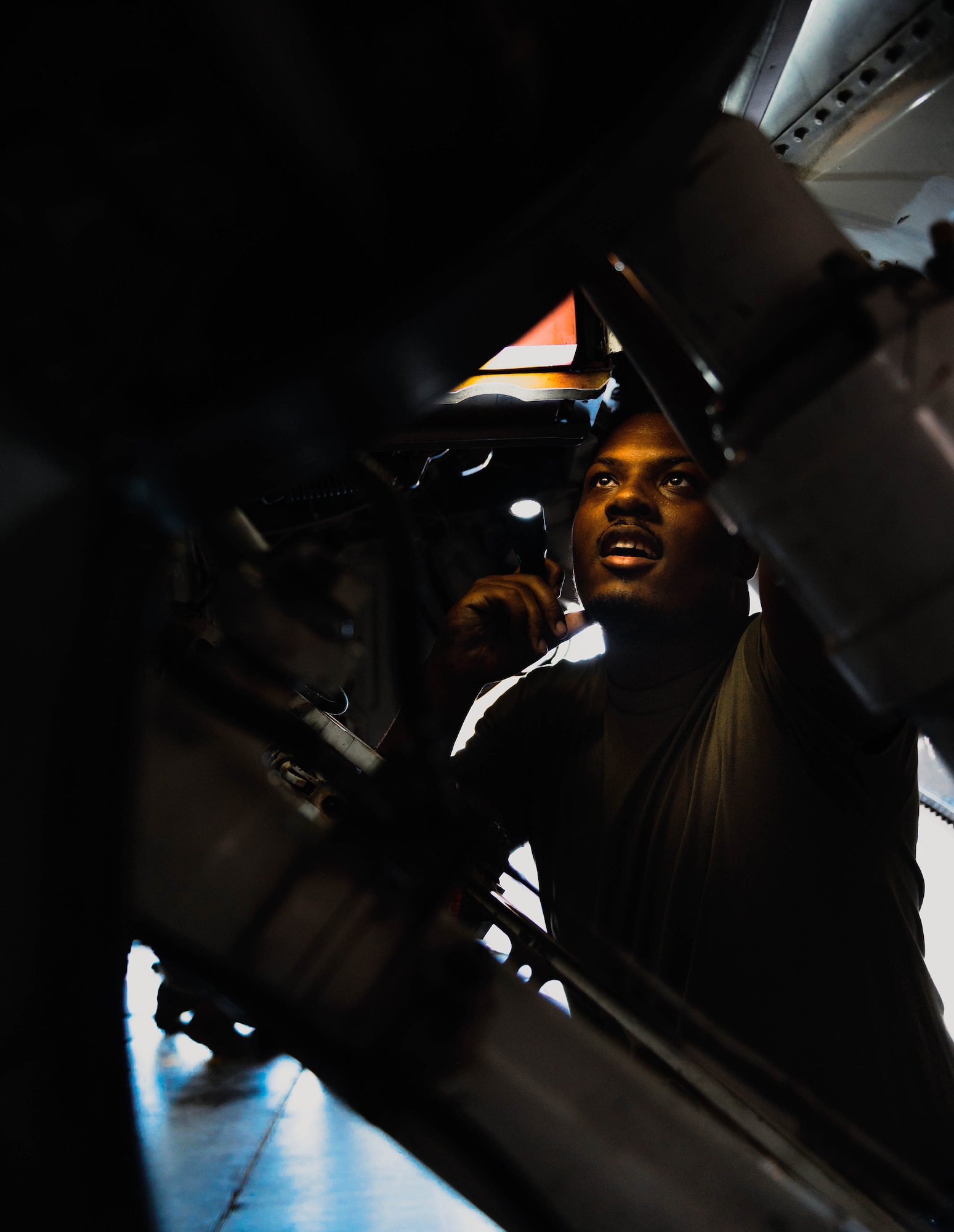 U.S. Air Force Senior Airman Ayo Motley, 309th Fighter Squadron engine specialist, examines an F-16 Fighting Falcon.