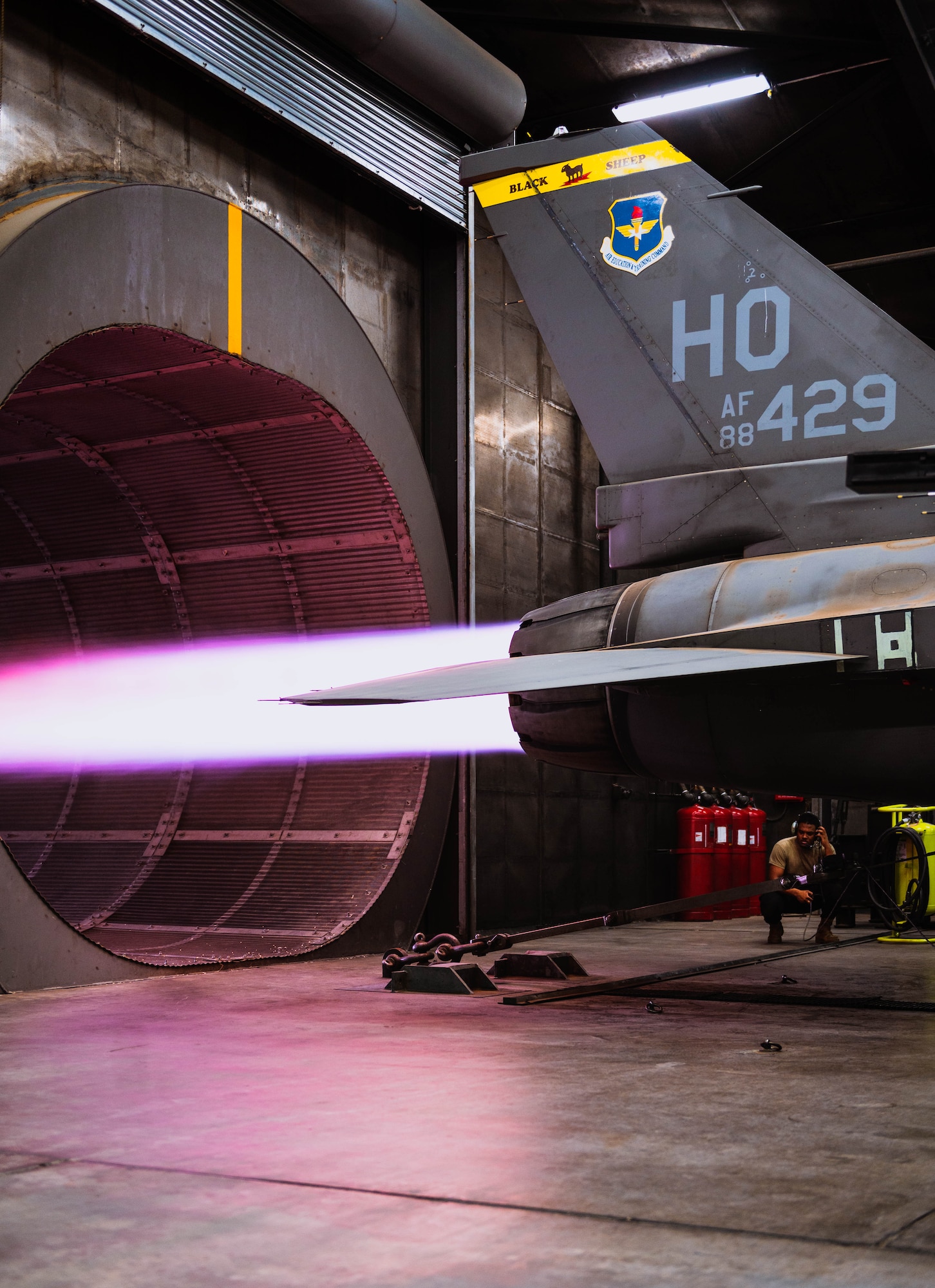 U.S. Air Force Senior Airman Ayo Motley, 309th Fighter Squadron engine specialist, stands by as ground control during installed engine operation certification for the General Electric F110 powered Bock 40 F-16 Fighting Falcon.