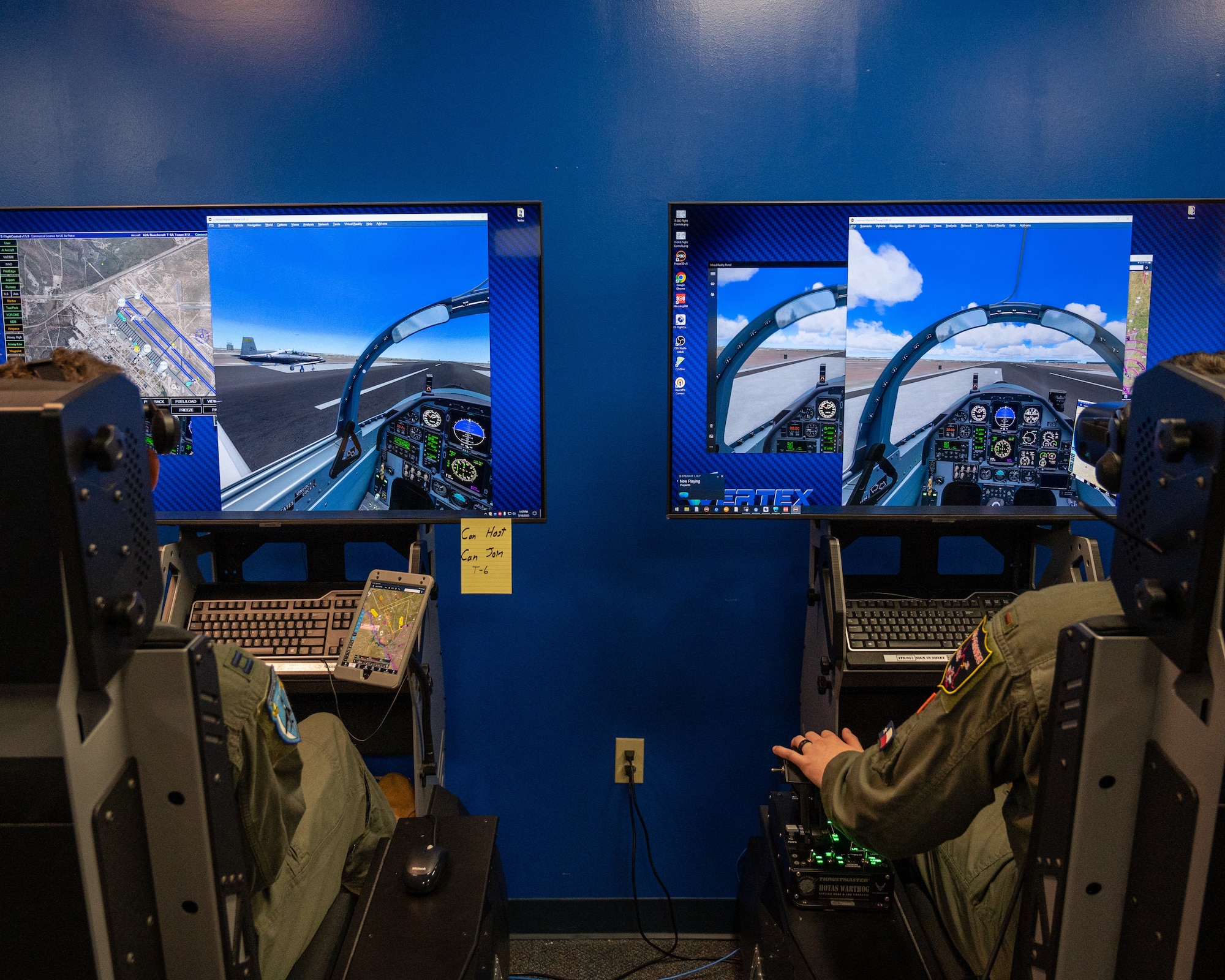 U.S. Air Force Capt. Roderick Walker (right) and 2nd Lt. Christian Lobiondo (left), 47th Student Squadron student pilots, fly together in virtual reality at Laughlin Air Force Base, Texas, July 20, 2023.  Student pilots are able to practice maneuvers in VR with other students, allowing formation flights can communications practice. (U.S. Air Force photo by Senior Airman Nicholas Larsen)