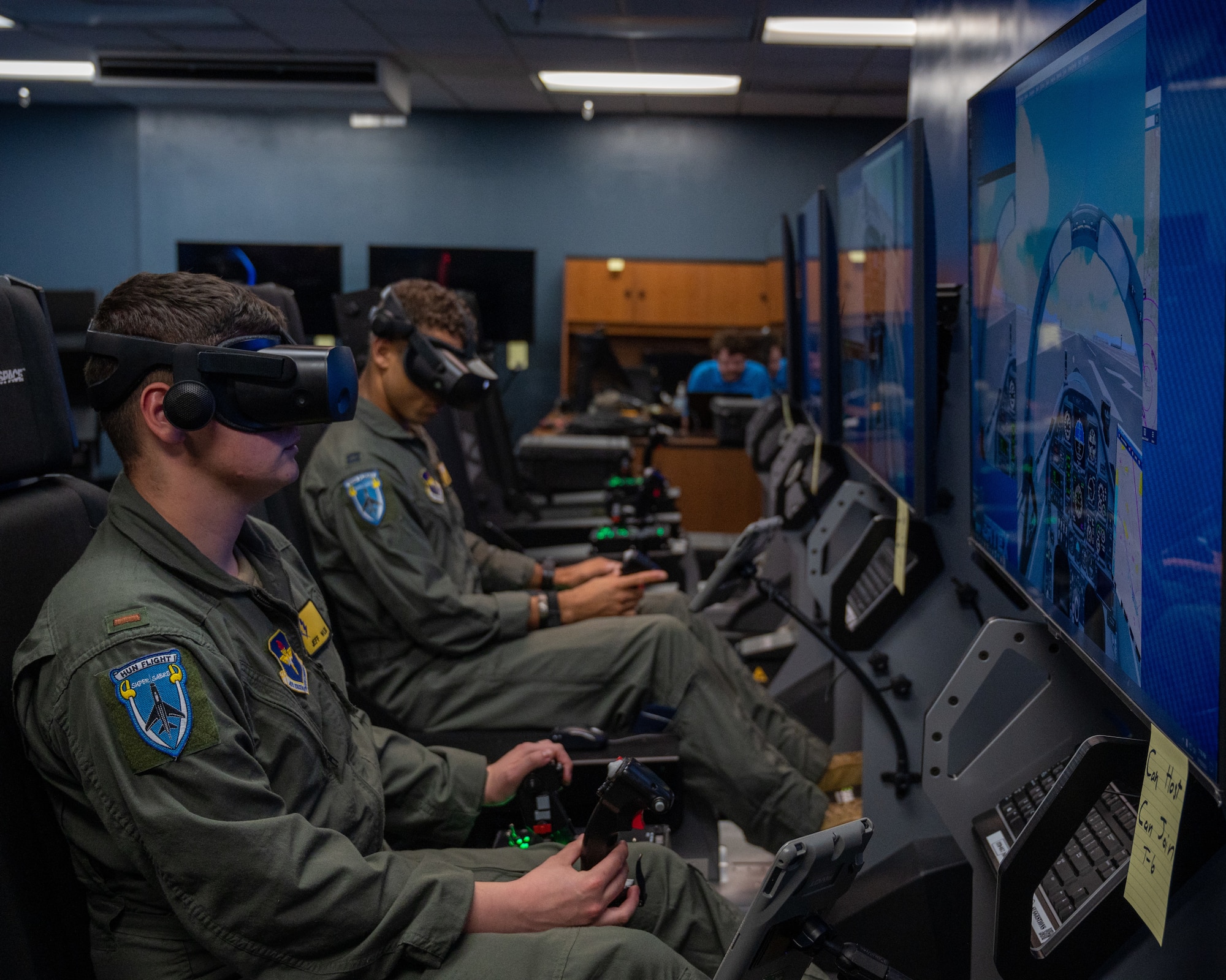 U.S. Air Force 2nd Lt. Christian Lobiondo (left) and Capt. Roderick Walker (right), 47th Student Squadron student pilots, fly together in virtual reality at Laughlin Air Force Base, Texas, July 20, 2023. Student pilots are able to practice maneuvers in VR with other students, allowing formation flights can communications practice. (U.S. Air Force photo by Senior Airman Nicholas Larsen)