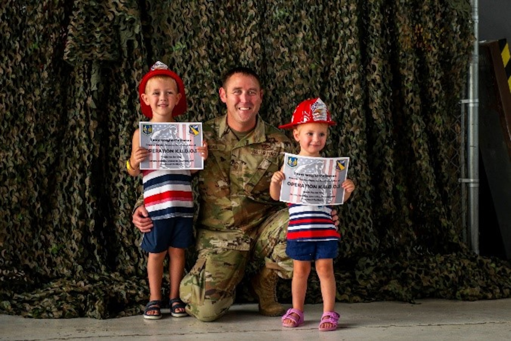 Senior Master Sgt. Justin Musall, 88th Air Base Wing Safety Office superintendent. and his children pose for a photo after Operation KUDOS on July 28 at Wright-Patterson Air Force Base, Ohio. The children who participated in the Kids Understanding Deployment Operations event were awarded a certificate at the end for their efforts. (U.S. Air Force photo by Airman 1st Class James Johnson)