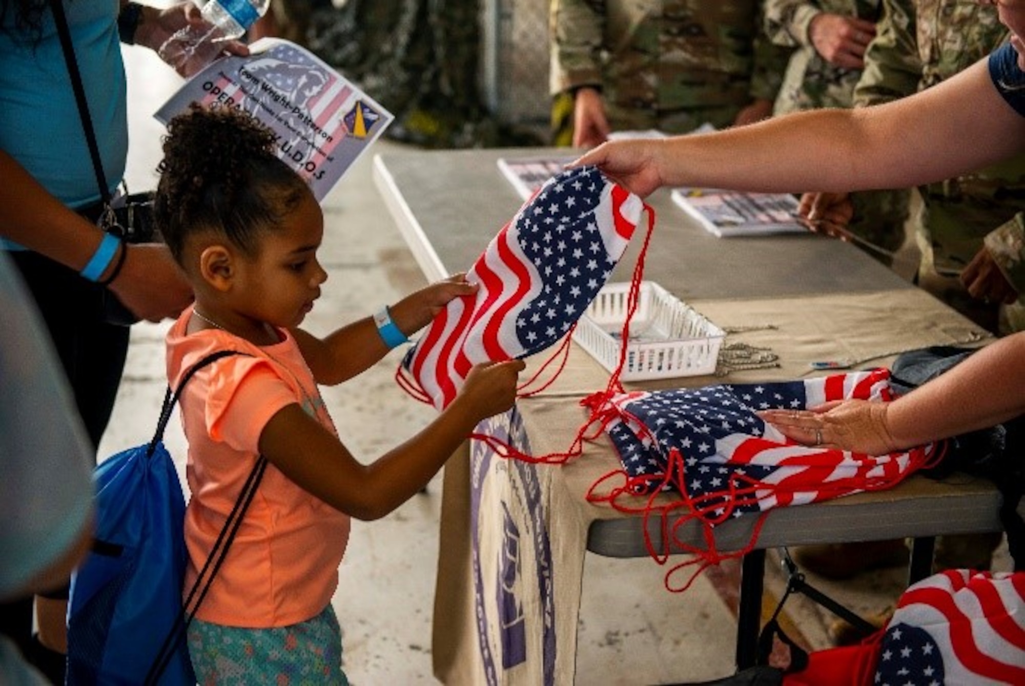 A child is given an American flag bag after participating in Operation KUDOS on July 28 at Wright-Patterson Air Force Base, Ohio. The annual Kids Understanding Deployment Operations event is designed to teach children in military families about deployments through engaging activities. (U.S. Air Force photo by Airman 1st Class James Johnson)