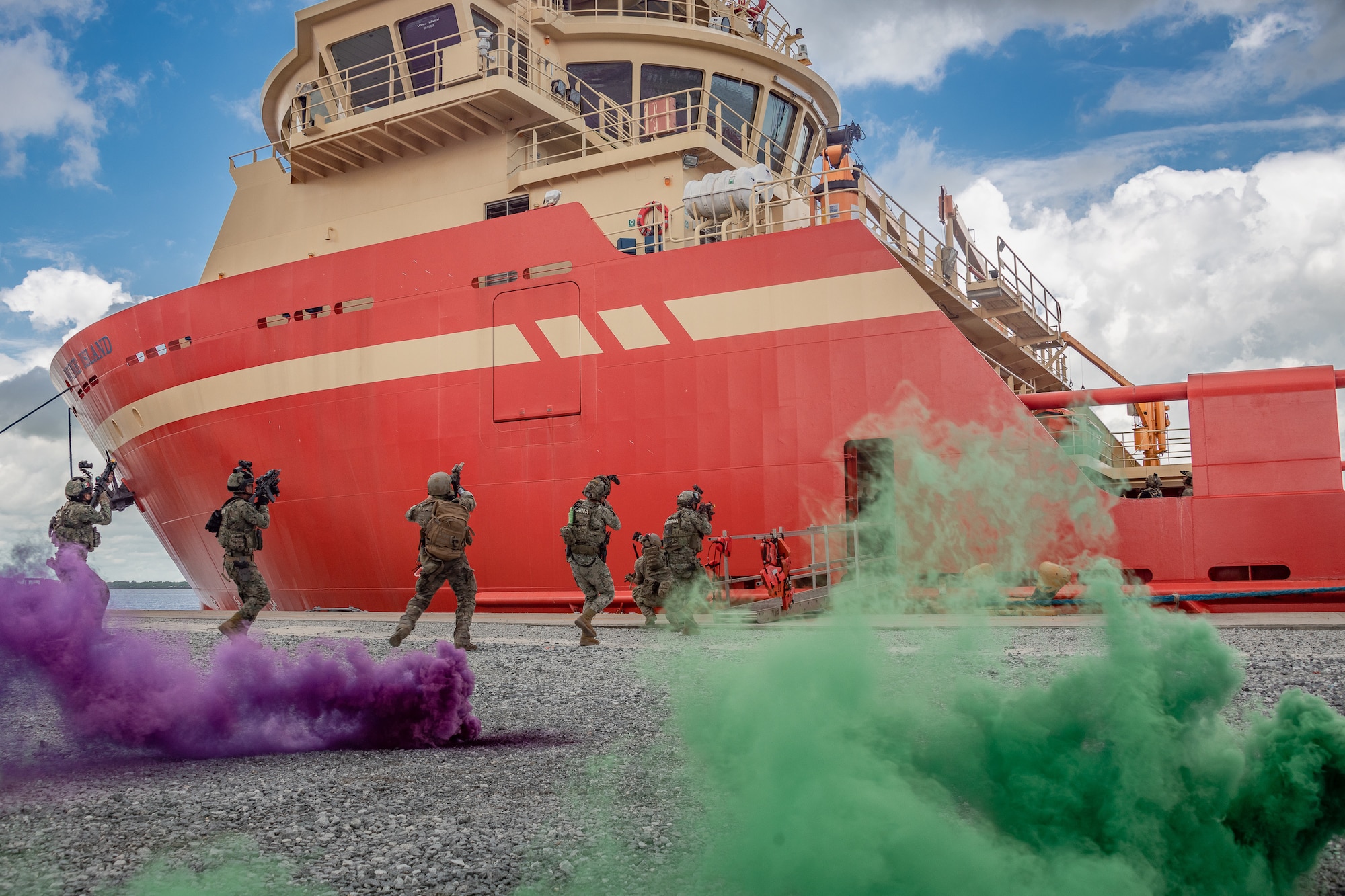 Multinational troops from Guyana, Mexico, Trinidad and Tobago and the U.S. board a vessel moored at a shore base facility for an anti-piracy exercise during Tradewinds 23 exercise in Georgetown, Guyana, July 24, 2023. This training exercise incorporated volunteers as opposition forces for the four nations to experience operating with real people in a high-stress environment. (U.S. Air National Guard photo by Tech. Sgt. Brigette Waltermire)