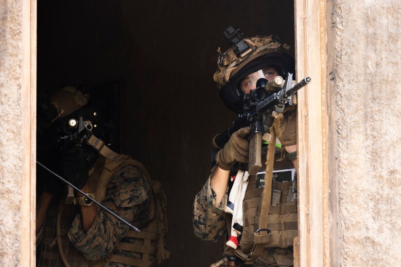 Two Marines aim weapons.