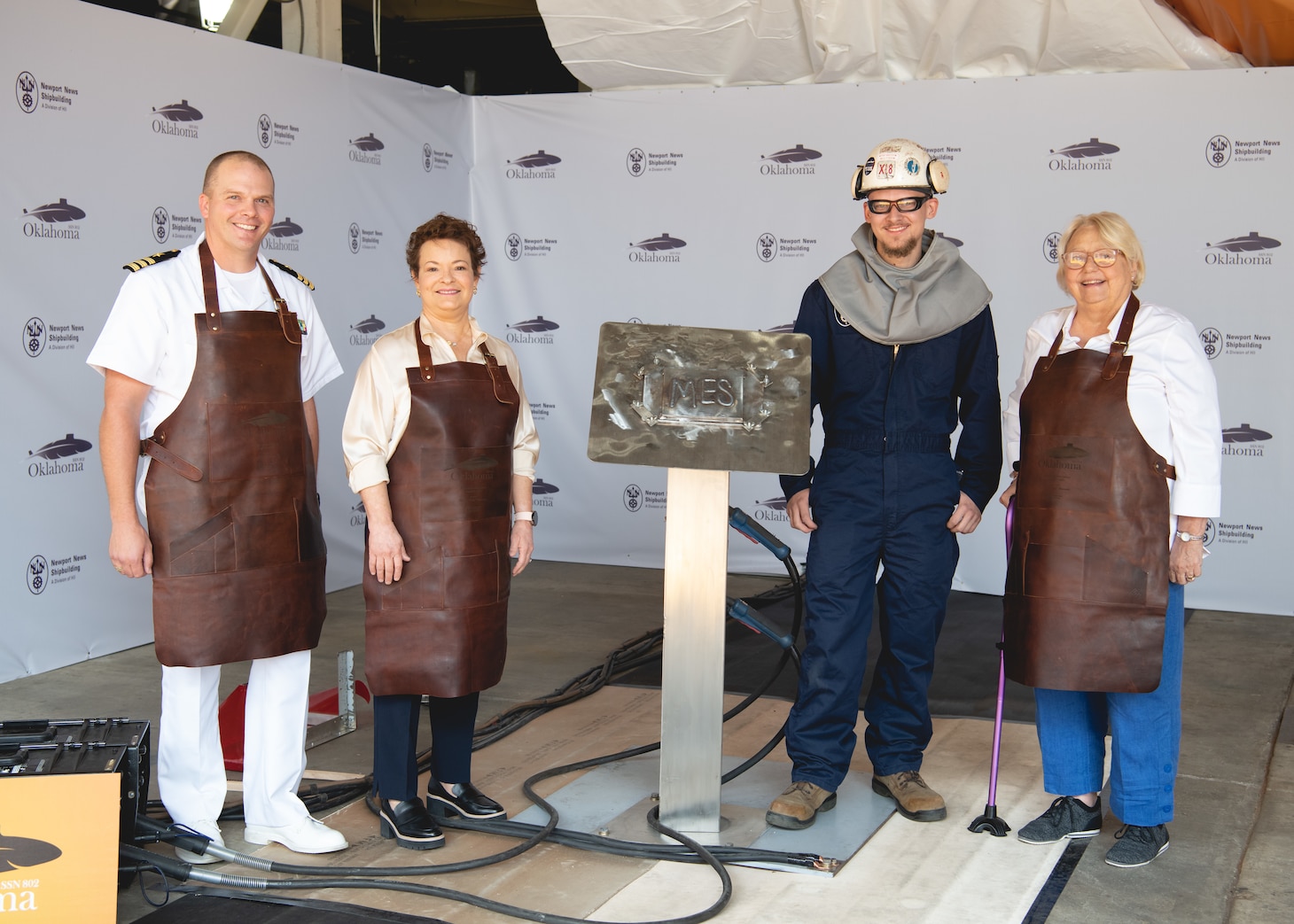 From left, Cmdr. Aaron Stutzman, commanding officer of the pre-commissioning unit, Newport News Shipbuilding President Jennifer Boykin, NNS welder Alex VanCampen, and ship’s sponsor Mary “Molly” Slavonic at the keel authentication ceremony for Virginia-class attack submarine Oklahoma (SSN 802) at HII’s Newport News Shipbuilding division on Wednesday, August 2, 2023 (Photo by Ashley Cowan/HII).