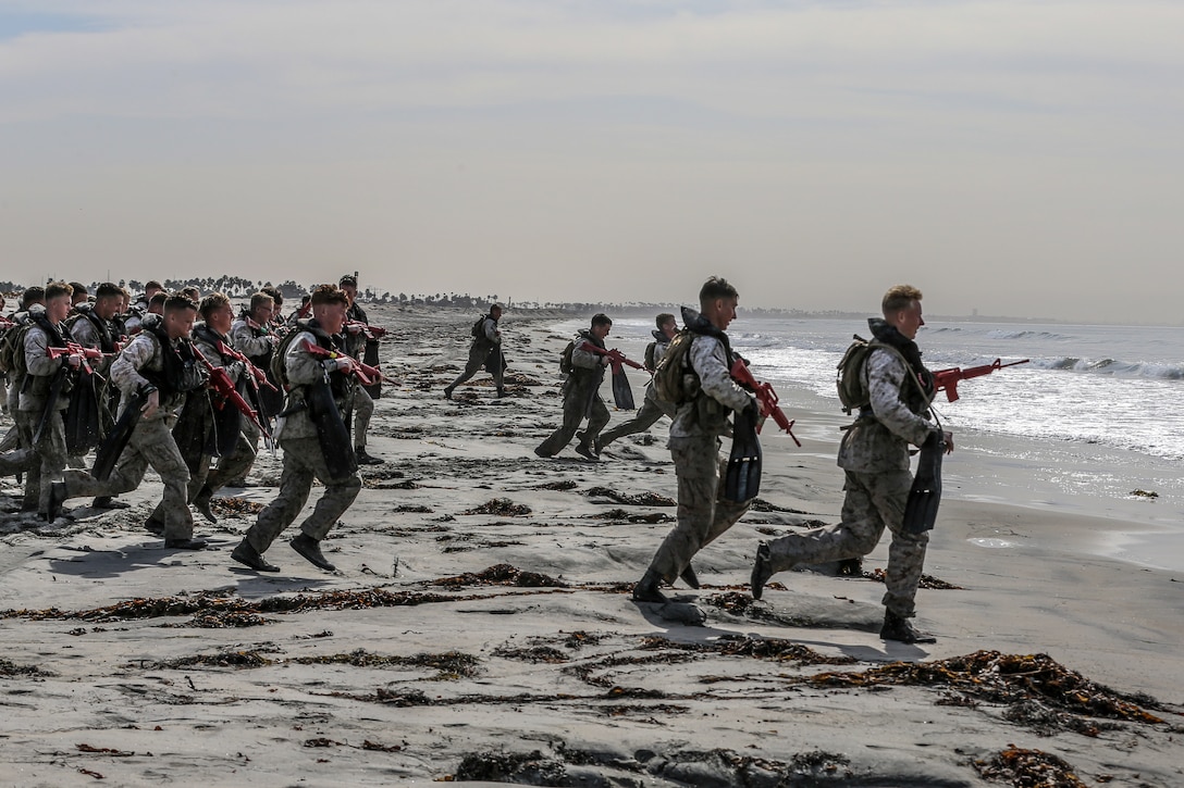 U.S. Marines with Basic Reconnaissance Course run into the ocean during clandestine landing and withdraw training at Naval Amphibious Base Coronado, California, Oct. 30, 2019. BRC is one of the many courses taught by the staff at Reconnaissance Training Company, Advanced Infantry Training Battalion, School of Infantry - West.  The course  provides students with the basic knowledge of reconnaissance doctrine, concepts, and techniques with emphasis on amphibious entry and extraction, beach reconnaissance and reconnaissance patrolling skills. (Marine Corps photo by Lance Cpl. Andrew Cortez)