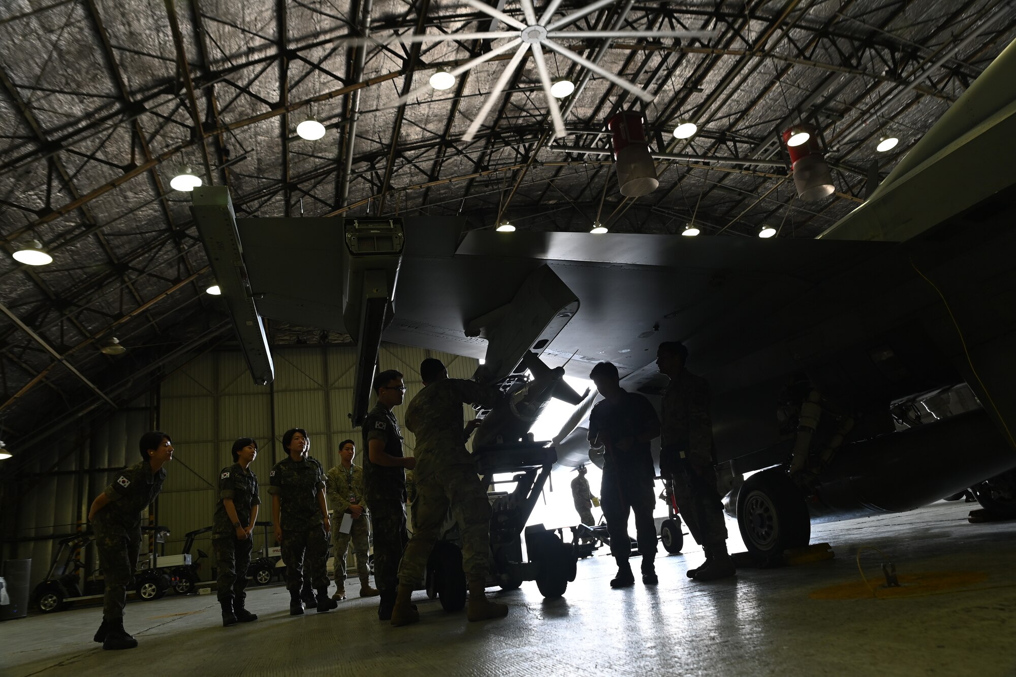Republic of Korea Air Force interpretation officers in training observe a weapons load demonstration by U.S. Air Force Airmen from the 51st Maintenance Group during an immersion tour at Osan Air Base, ROK, July 25, 2023.
