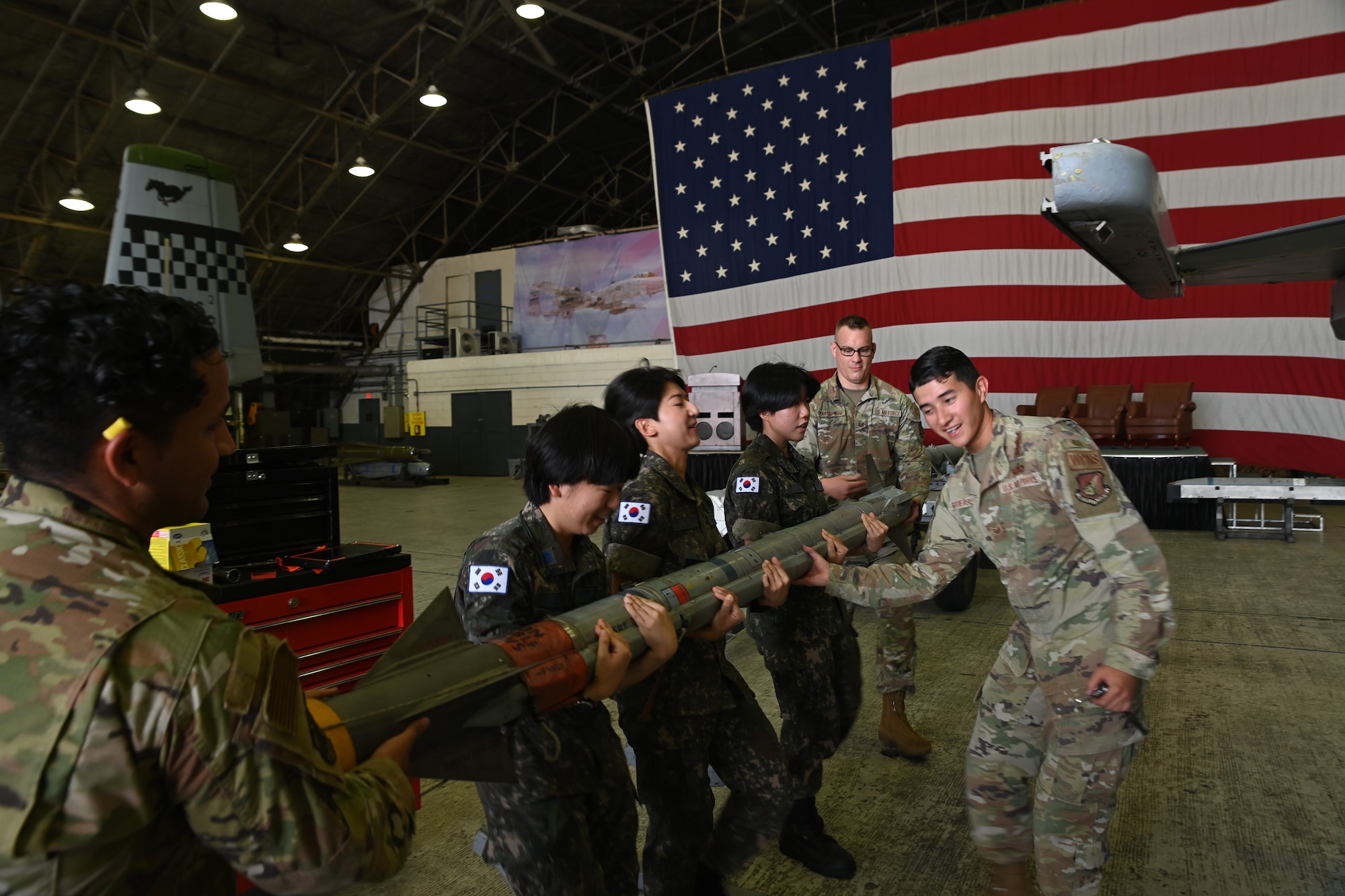 Republic of Korea Air Force interpretation officers in training participate in a weapons load demonstration by U.S. Air Force Airmen from the 51st Maintenance Group during an immersion tour at Osan Air Base, ROK, July 25, 2023.