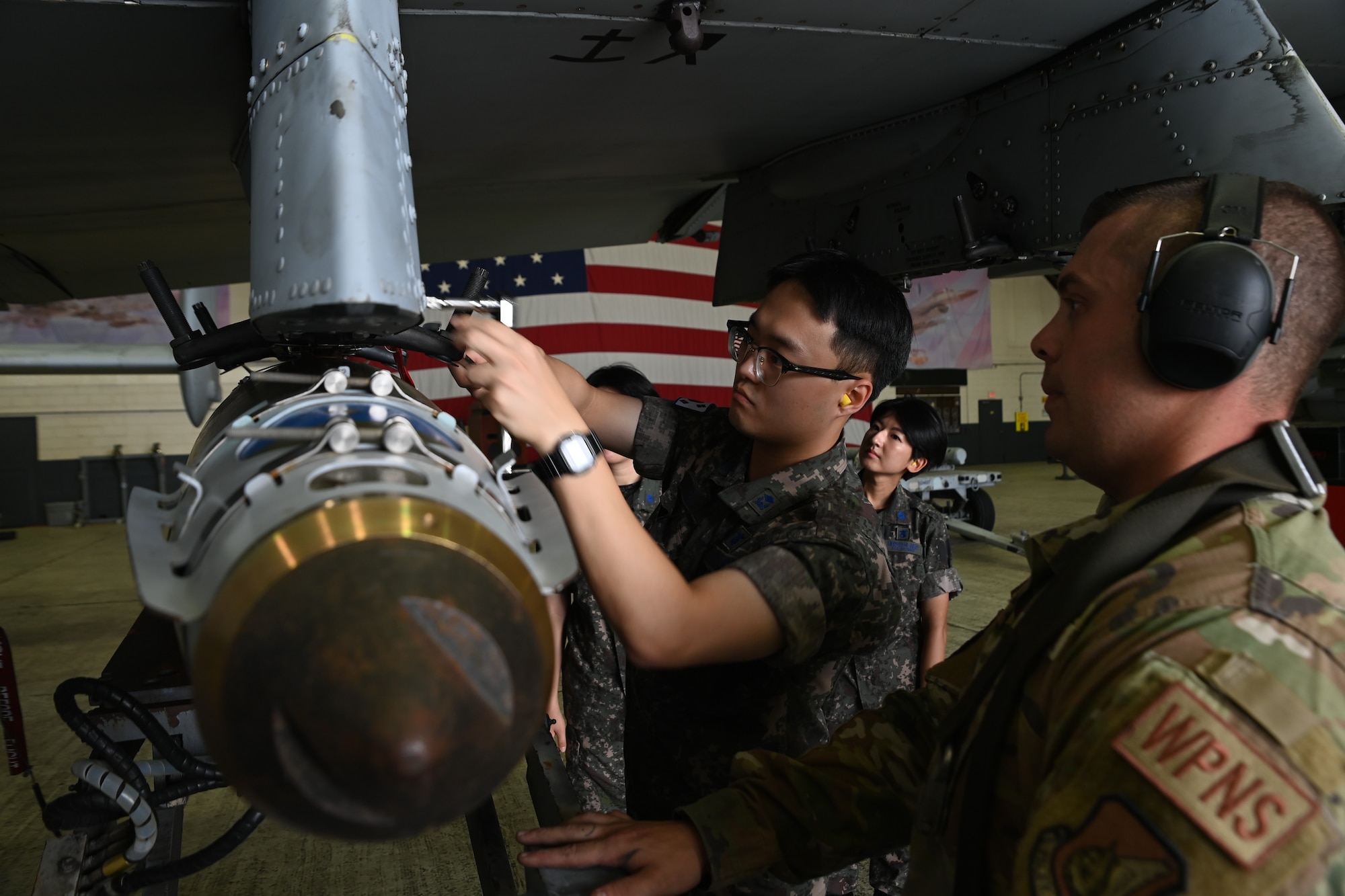 Republic of Korea Air Force interpretation officers in training participate in a weapons load demonstration by U.S. Air Force Airmen from the 51st Maintenance Group during an immersion tour at Osan Air Base, ROK, July 25, 2023.