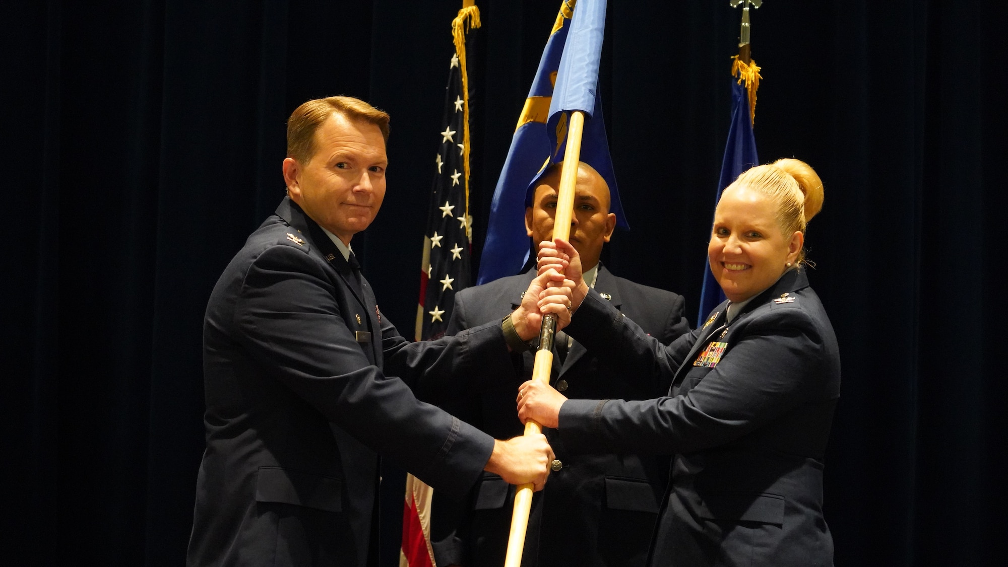 Col. Catherine Callender accepts the 88th Operational Medical Readiness Squadron guidon from Col. Dale Harrell, 88th Medical Group commander, during a change of command ceremony July 28 in the Wright-Patterson Medical Center auditorium.
