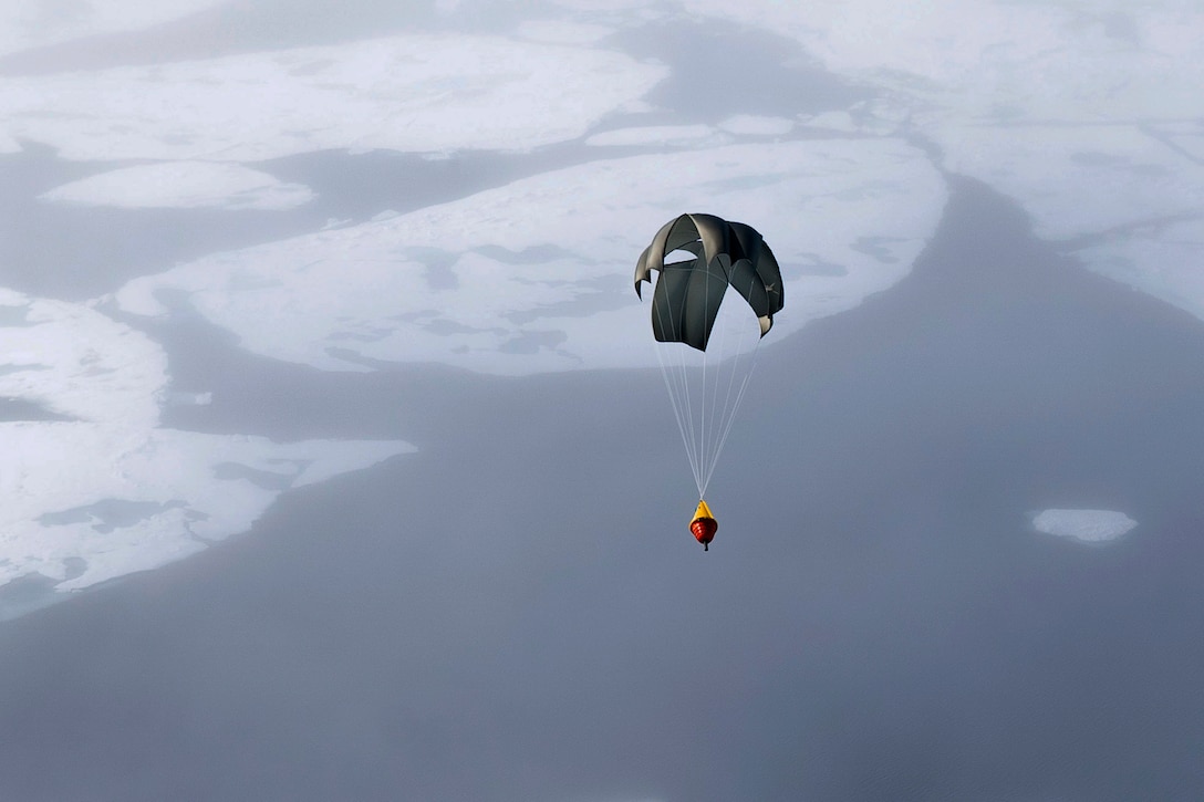 A buoy falls from a plane over an icy ocean.