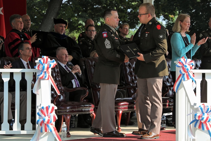 U.S. Army Spc. Isaac Junkin with Bravo Company, 1st Battalion, 112th Infantry Regiment, 56th Stryker Brigade Combat Team, Pennsylvania Army National Guard, accepts the certificate for a master’s degree in strategic studies July 28, 2023, at the Army War College in Carlisle, Pennsylvania, on behalf of his father Lt. Col. Francisco Junkin. Lt. Col. Junkin passed away April 8, 2023, at the age of 46. (U.S. Army National Guard photo by Sgt. 1st Class Zane Craig)