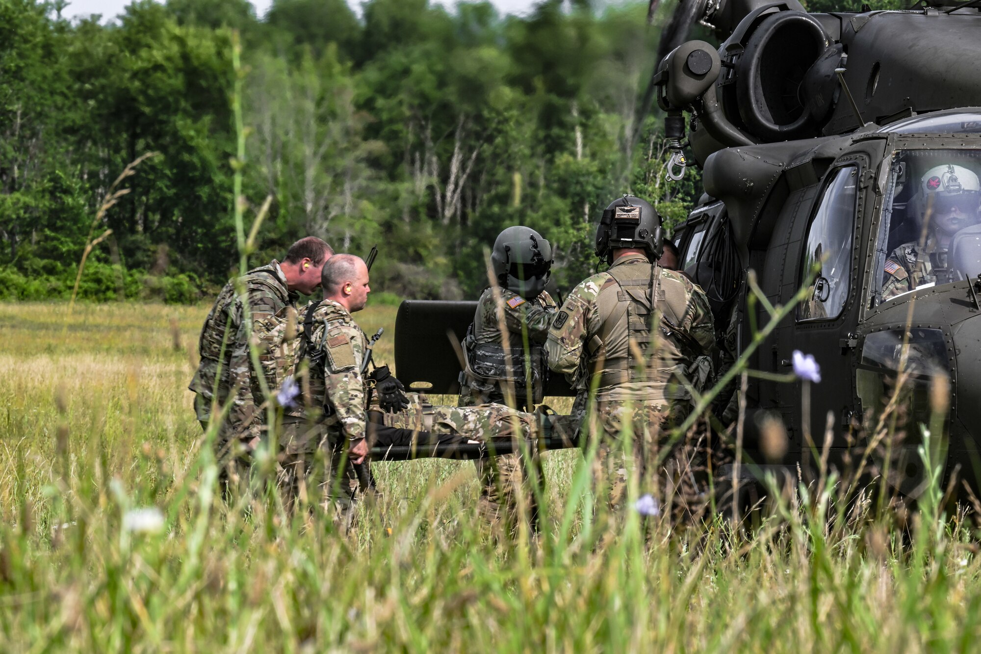 Defenders assigned to the 910th Security Forces Squadron load a litter onto a 3rd Batallion, 238th Air Regiment UH-60 Blackhawk helicopter on July 25, 2023, at Camp James A. Garfield Joint Military Training Center, Ohio.