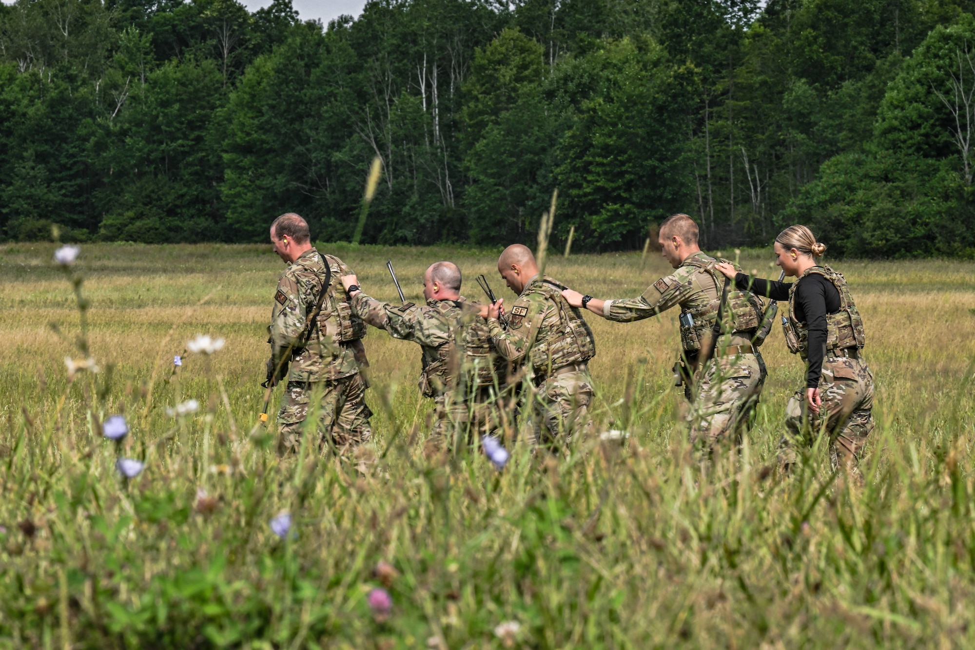 Defenders assigned to the 910th Security Forces Squadron walk away from a 3rd Batallion, 238th Air Regiment UH-60 Blackhawk helicopter after loading a litter onto the aircraft on July 25, 2023, at Camp James A. Garfield Joint Military Training Center, Ohio.