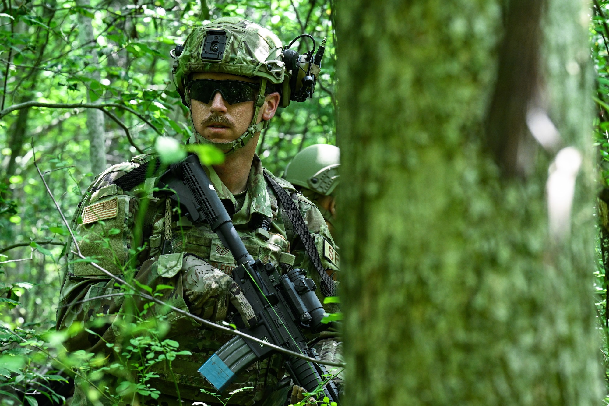 Staff Sgt. Cason George, a 920th Security Forces Squadron Defender from Patrick Air Force Base, Florida, walks through the woods during a land navigation exercise on July 25, 2023, at Camp James A. Garfield Joint Military Training Center, Ohio.