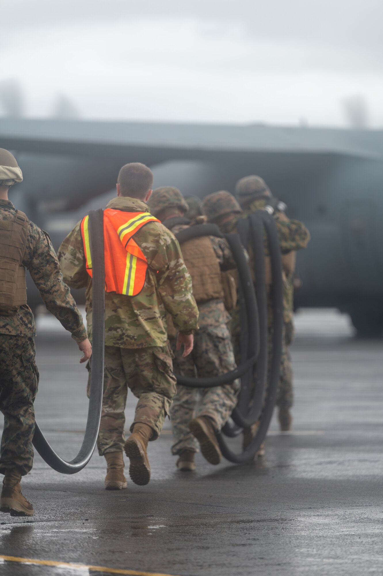U.S. Air Force Airmen, assigned to Davis-Monthan Air Force Base, Arizona and Marine Corps Marines, assigned to Marine Wing Support Squadron 373, pick up a fuel line together during a forward arming and refueling exercise for Cope Thunder 23-2 at Subic Bay International Airport, Philippines, July 15, 2023. Cope Thunder 23-2 was an exercise with the goal to improve regional security and protect a free and open Indo-Pacific. (U.S. Air Force photo by Senior Airman Vaughn Weber)