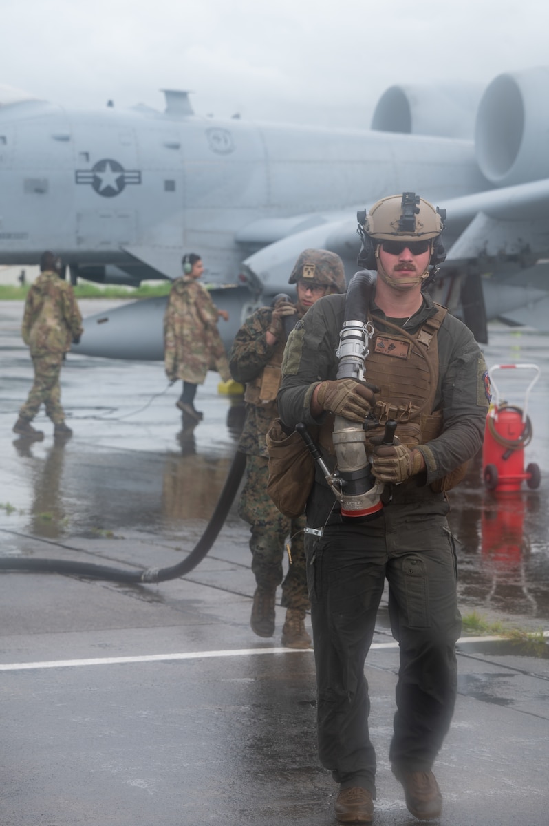 A U.S. Marine Corps Marine, assigned to Marine Wing Support Squadron 373, carries a hose during a forward arming and refueling exercise for Cope Thunder 23-2 at Subic Bay International Airport, Philippines, July 15, 2023. Cope Thunder 23-2 provided valuable training to aircrews allowing joint foreign forces to work together and improve interoperability. (U.S. Air Force photo by Senior Airman Vaughn Weber)
