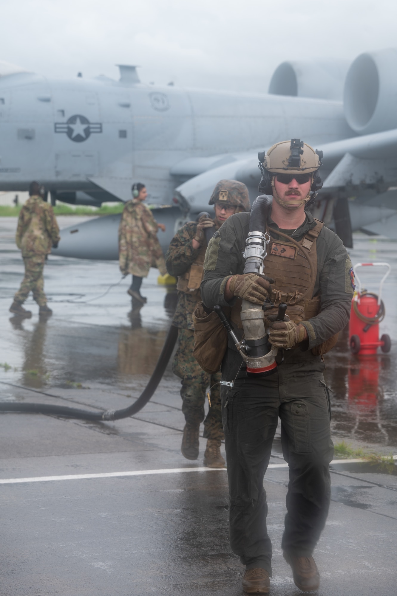 A U.S. Marine Corps Marine, assigned to Marine Wing Support Squadron 373, carries a hose during a forward arming and refueling exercise for Cope Thunder 23-2 at Subic Bay International Airport, Philippines, July 15, 2023. Cope Thunder 23-2 provided valuable training to aircrews allowing joint foreign forces to work together and improve interoperability. (U.S. Air Force photo by Senior Airman Vaughn Weber)