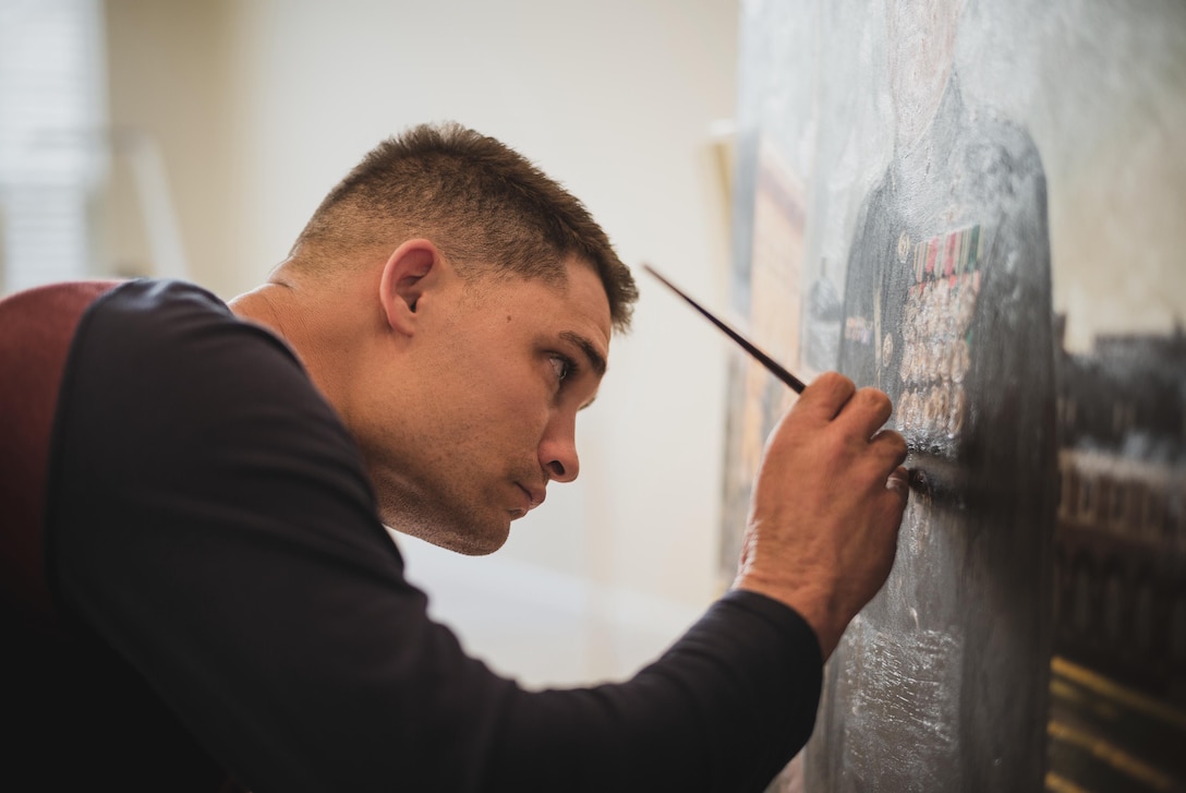 U.S. Marine Corps Maj. Charles Baumann, a logistics officer with 8th Marine Corps District, applies final touches to the portrait of the 38th commandant of the Marine Corps in Washington, March 2023. Baumann is the 2nd active-duty combat artist selected to paint a portrait of a commandant of the Marine Corps.