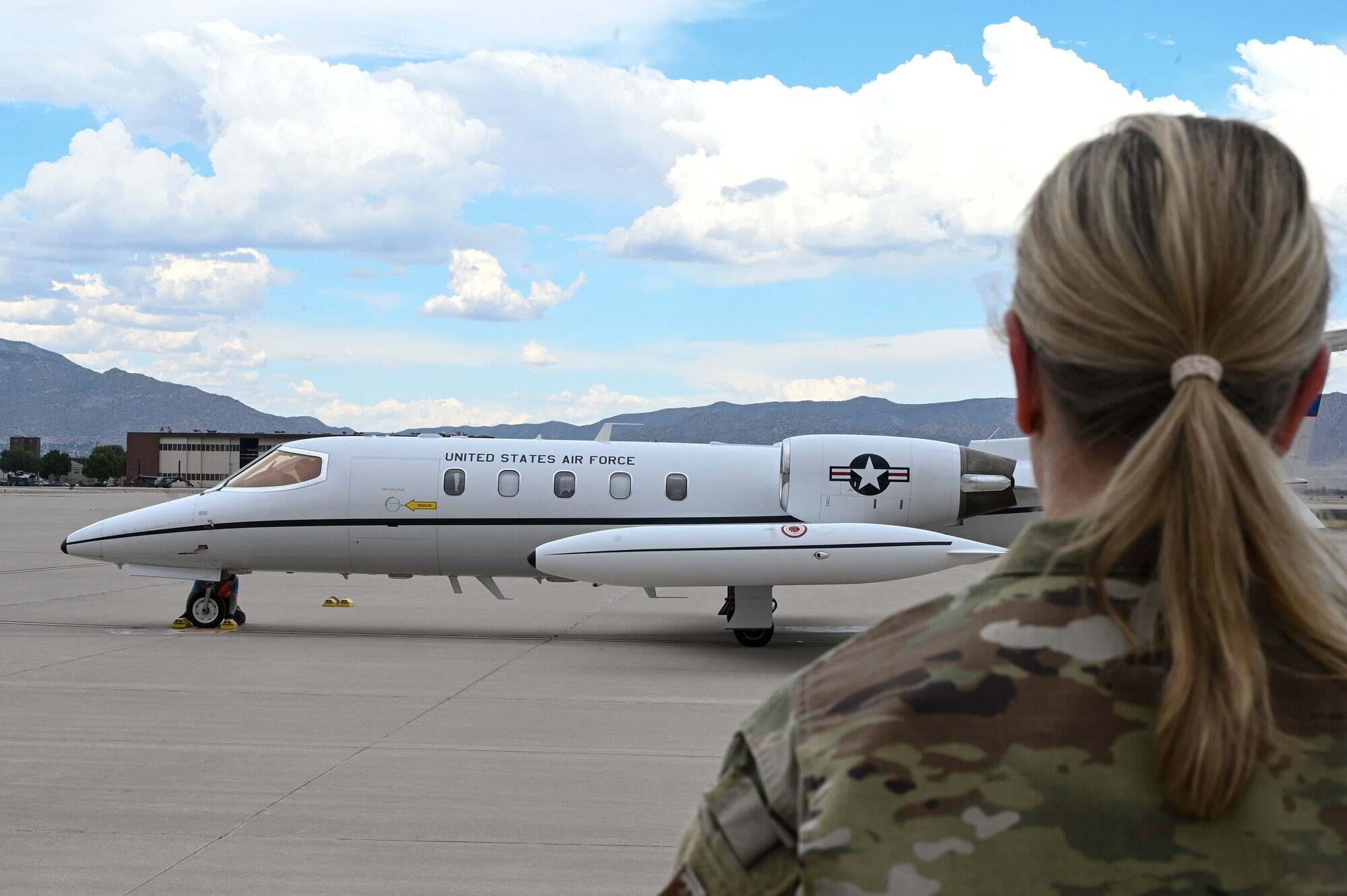 A woman watches a plane.