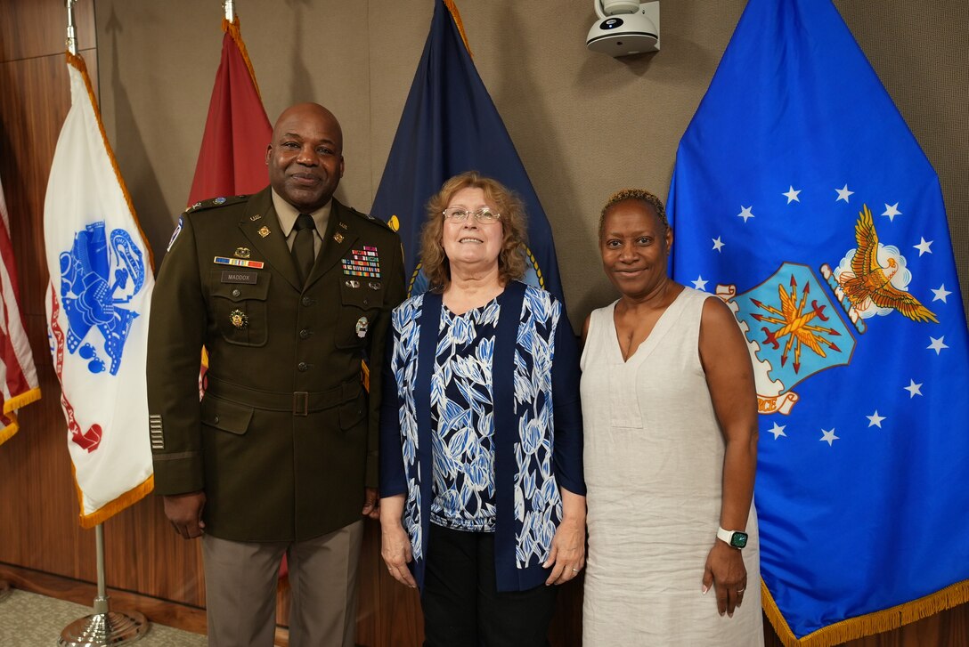 Retirees, Joyce Wilson and Sharon Mcintosh-Mason, pose with Defense Logistics Agency Troop Support Commander Army Col. Landis Maddox, after a ceremony in their honor. The two retired after a combined more than half-century of work with DLA Troop Support.