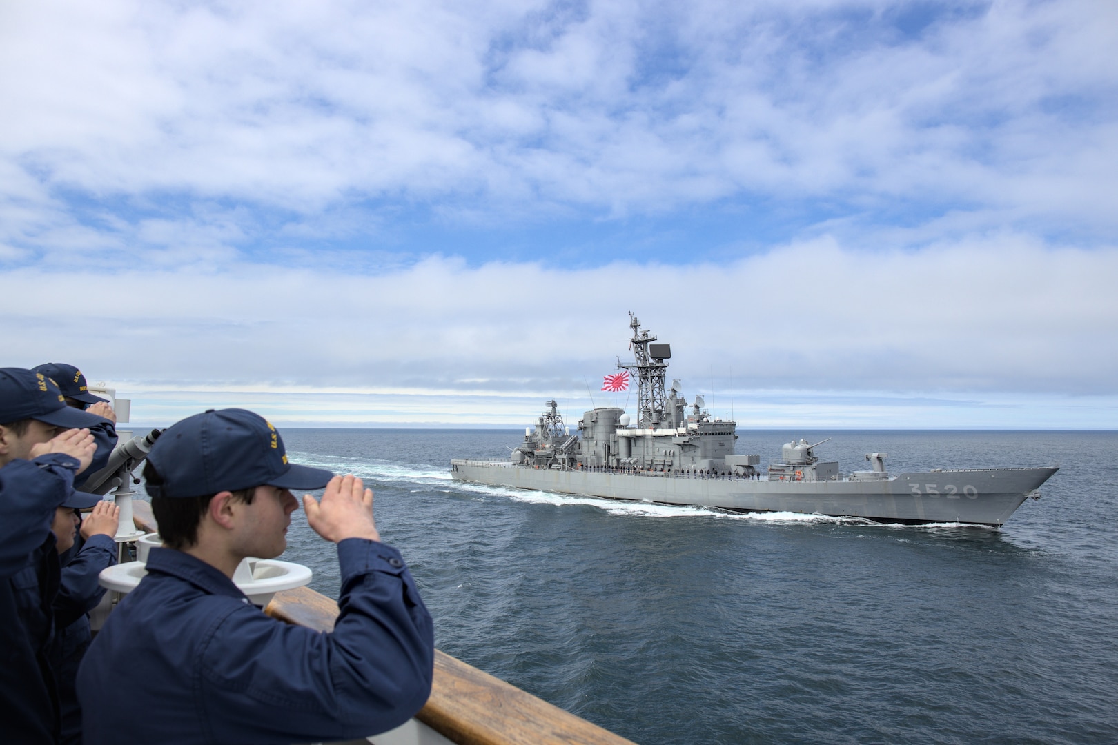 U.S. Coast Guard Cutter Bertholf (WMSL 750) crew members render honors to the Japanese Military Self Defense Force Training Ship HATAKAZE and crew from the bridge wing of Bertholf in the Bering Sea, June 3, 2023. In a demonstration of alliance between Japan and the United States, Bertholf conducted major at-sea and shore side engagements with the Japan Maritime Self Defense Force (JMSDF) training ships Kashima and Hatakaze. During the at-sea engagement, Bertholf, Kashima and Hatakaze executed multiple formations, and during a farewell pass, the JMSDF personnel displayed a highly impressive drumline performance on their flight deck. (U.S. Coast Guard photo by Chief Petty Officer Oliver Fernander)