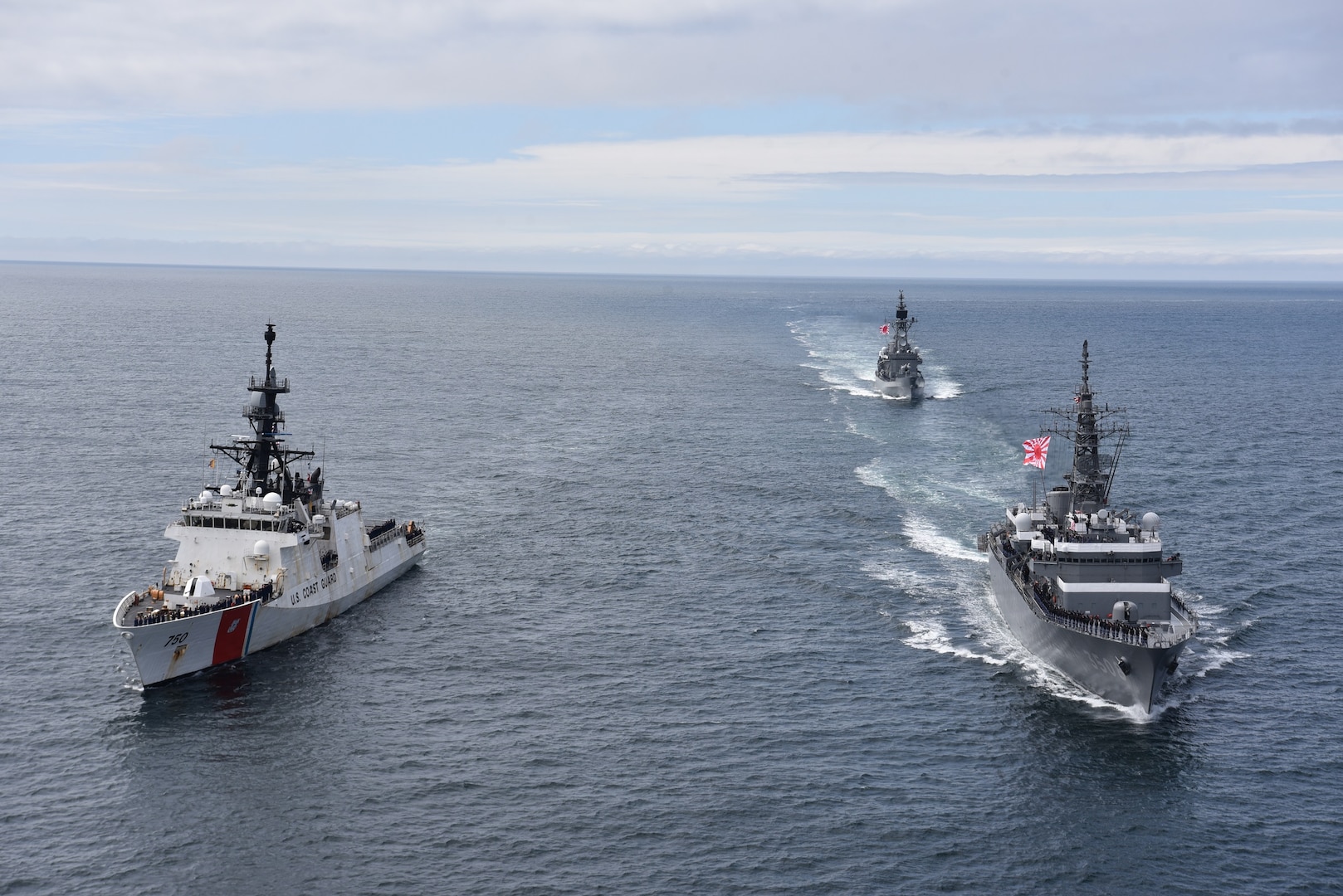 U.S. Coast Guard Cutter Bertholf (WMSL 750) sails alongside Japanese Military Self Defense Force Training Ships HATAKAZE and KASHIMA in the Bering Sea, June 3, 2023. In a demonstration of alliance between Japan and the United States, Bertholf conducted major at-sea and shore side engagements with the Japan Maritime Self Defense Force (JMSDF) training ships Kashima and Hatakaze. During the at-sea engagement, Bertholf, Kashima and Hatakaze executed multiple formations, and during a farewell pass, the JMSDF personnel displayed a highly impressive drumline performance on their flight deck. (U.S. Coast Guard photo by Lt. Cmdr. Scott McCann)
