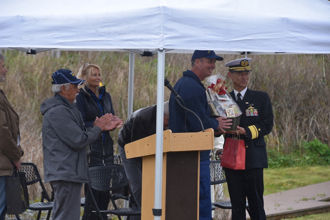 Rear Adm. Nathan Moore, U.S. Coast Guard Seventeenth District commander, and Rear Adm. Konno Yasushige, Japanese Military Self Defense Force Training commander, exchange gifts at the Battle of Dutch Harbor Memorial Ceremony in Unalaska, Alaska, June 6, 2023. The Japanese and U.S. crews came together with the Unalaska community and officials from the Qawalangin Tribe during the 81st anniversary of the WW II Battle of Dutch Harbor ceremony to commemorate the lives lost, the community impacts, and to recognize the healing and partnership that has been built in the decades that followed.  (U.S. Coast Guard photo by Ensign John Overstreet)