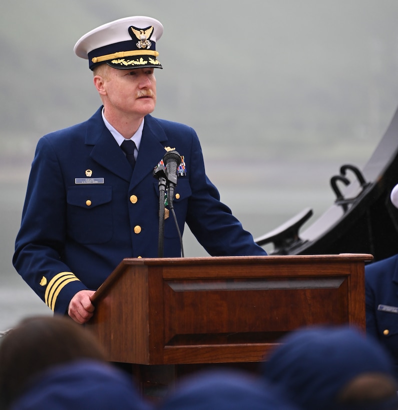 U.S. Coast Guard Cdr. Daniel Davis provides a farewell address to Cypress crewmembers during a change-of-command ceremony at Base Kodiak, Aug. 3, 2023. Cypress arrived to Kodiak in December 2021, succeeding the now decommissioned U.S. Coast Guard Cutter Spar as the ocean-going buoy tender responsible for 153 aids to navigation throughout the Kodiak Archipelago and the Aleutian Islands.U.S. Coast Guard photo by Petty Officer 3rd Class Ian Gray.