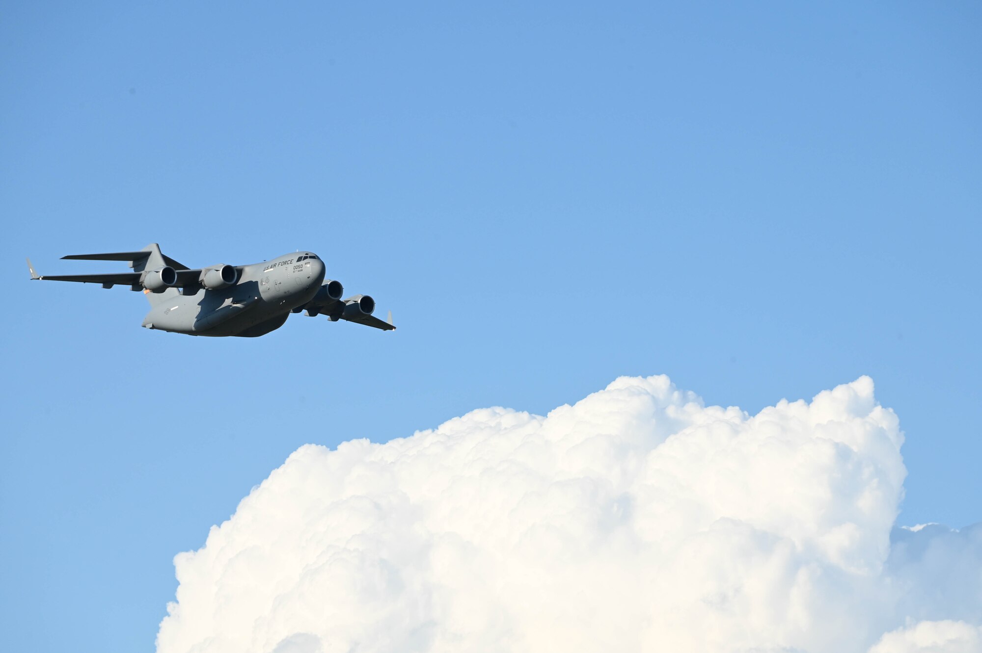 A C-17 Globemaster III from Altus Air Force Base, Oklahoma, flies over the Experimental Aircraft Association AirVenture Air Show in Oshkosh, Wisconsin, July 29, 2023. The C-17 was piloted by Maj. Jonathan Crawley, 58th Airlift Squadron assistant director of operations, and Maj. Emily Barkemeyer, 58th Airlift Squadron instructor pilot. (U.S. Air Force photo by Airman 1st Class Miyah Gray)