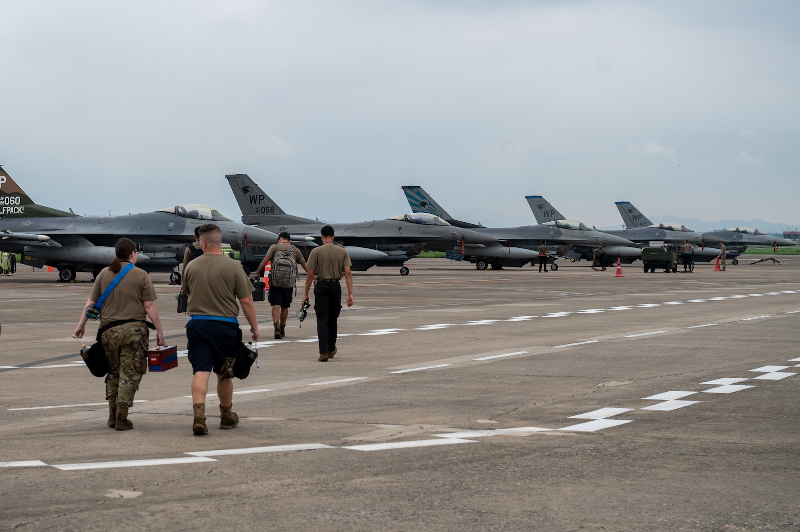 Members of the 35th Fighter Generation Squadron walk the flightline towards F-16 Fighting Falcons assigned to the 35th Fighter Squadron